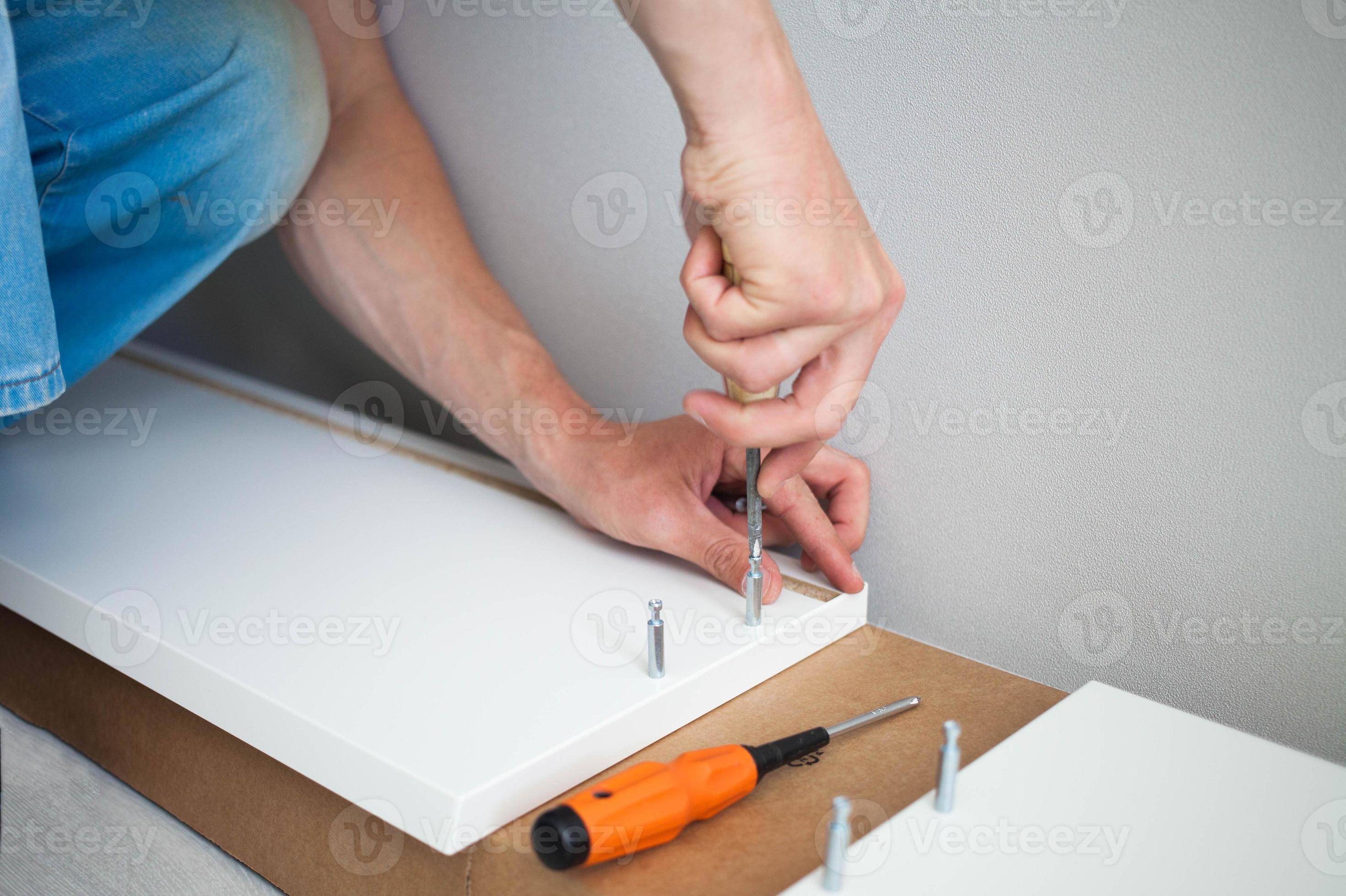 Close up of man hand, furniture assembler make flat pack white