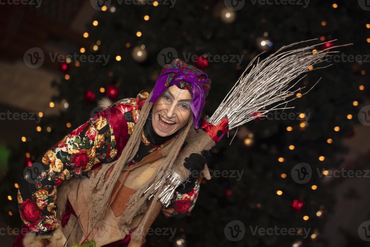 baba yaga con un Escoba en el antecedentes de el Navidad árbol.ruso bruja. foto