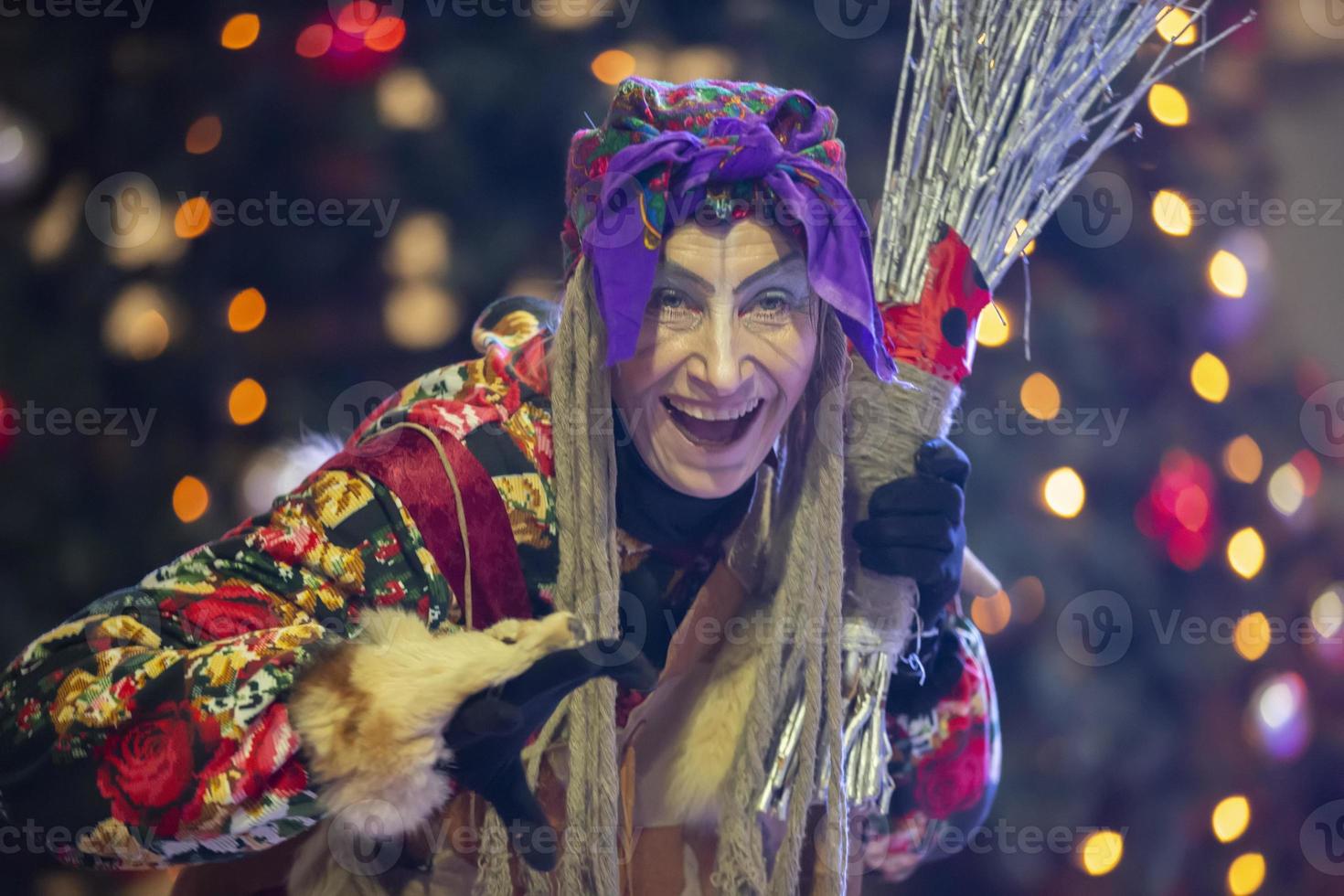 baba yaga con un Escoba en el antecedentes de el Navidad árbol. foto