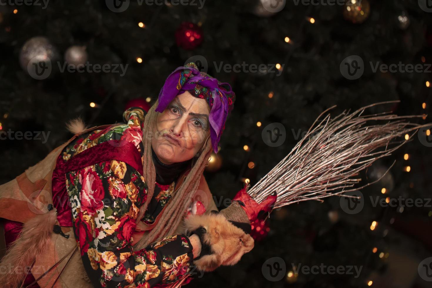 baba yaga con un Escoba en el antecedentes de el Navidad árbol.ruso bruja. foto