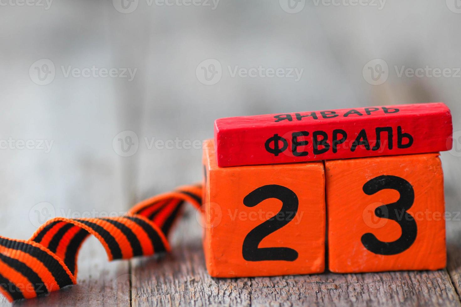 Wooden calendar with the date February 23 and george ribbon . Fatherland defender day. Father day. Men is day in Russia, Belarus, Tajikistan. Text in Russian February 23. Copy space. photo