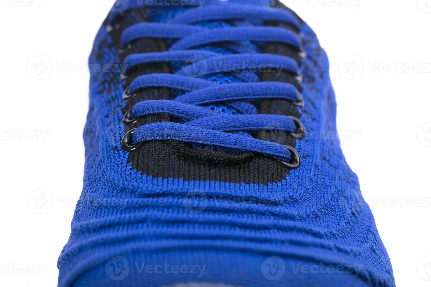 Part of a blue sneaker made of fabric with laces. A fragment of sports shoes. photo