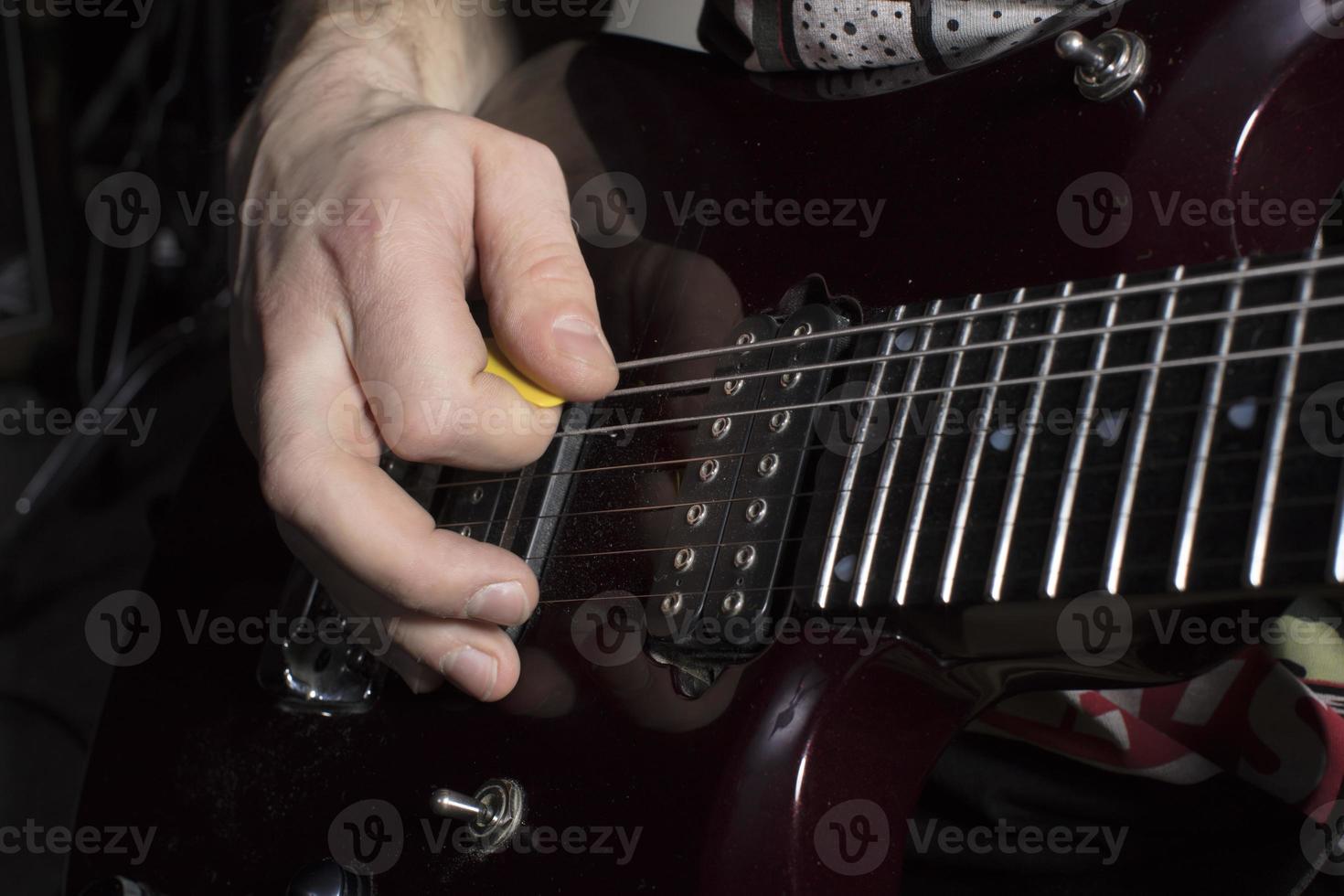 Hand plays the guitar. Iterate over the strings. photo