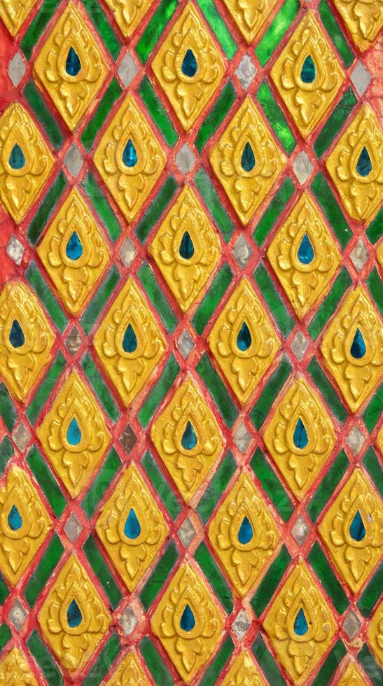 Pattern of gold flower carved on stucco design of native wall, Thai style in temple photo