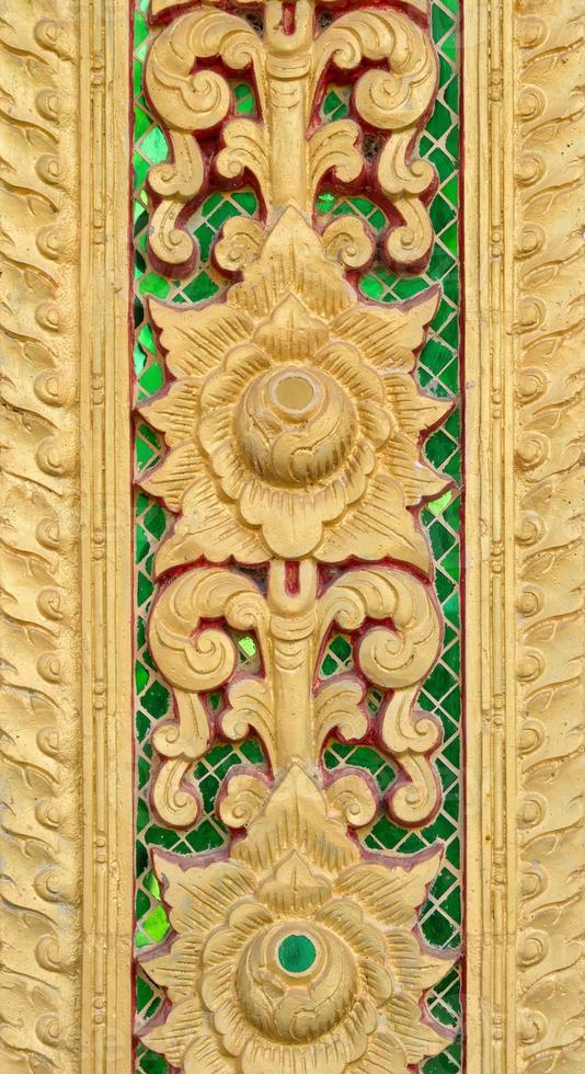 Pattern of gold flower carved on stucco design of native wall, Thai style in temple photo