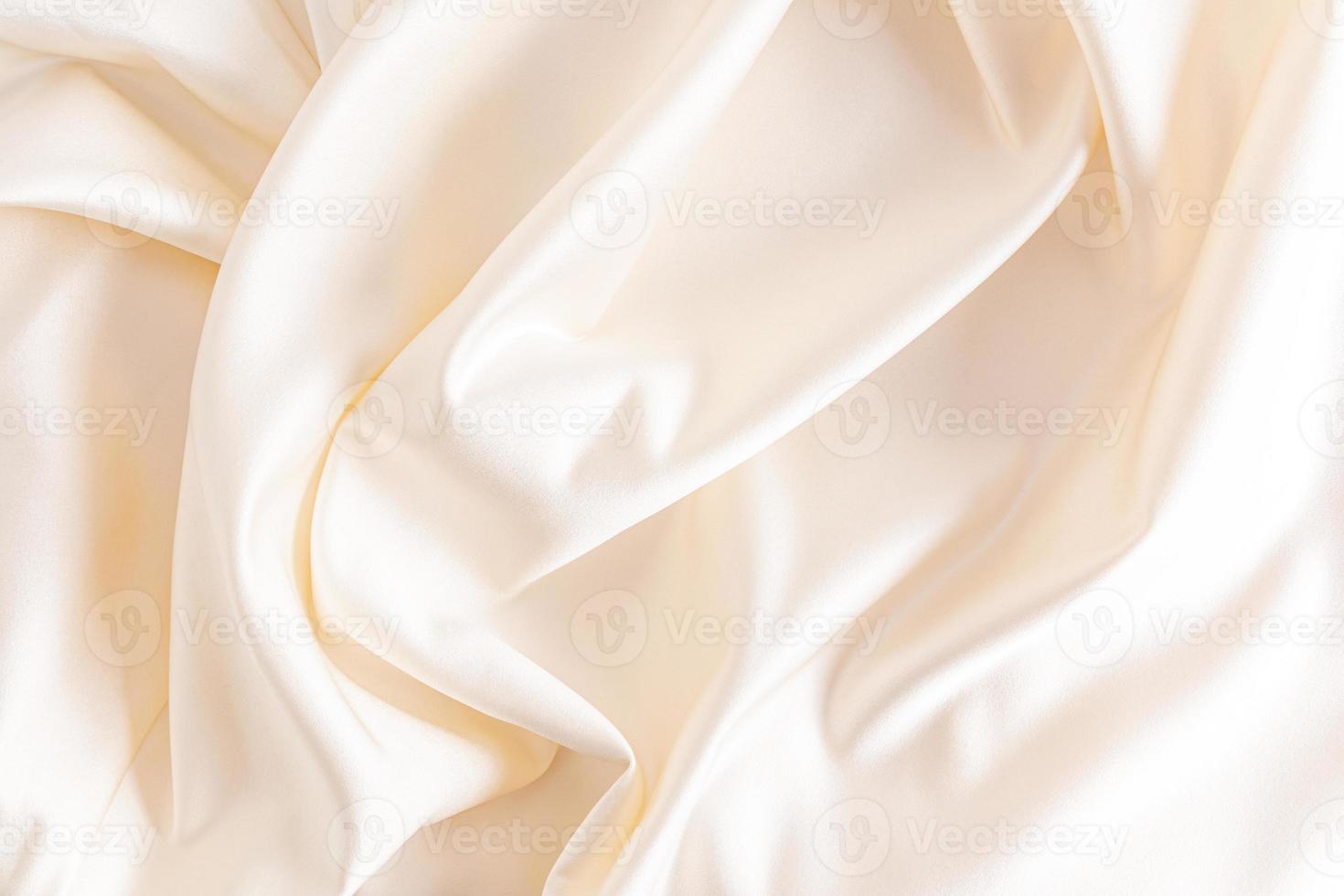 Luxurious satin fabric with delicate waves of beige color. wedding fabric background. photo