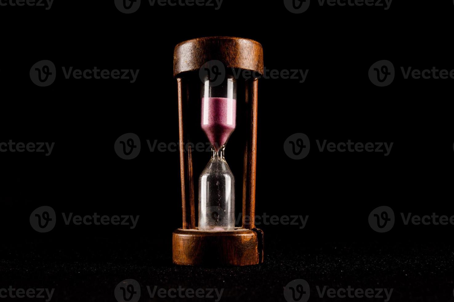 Hourglass isolated on black background photo