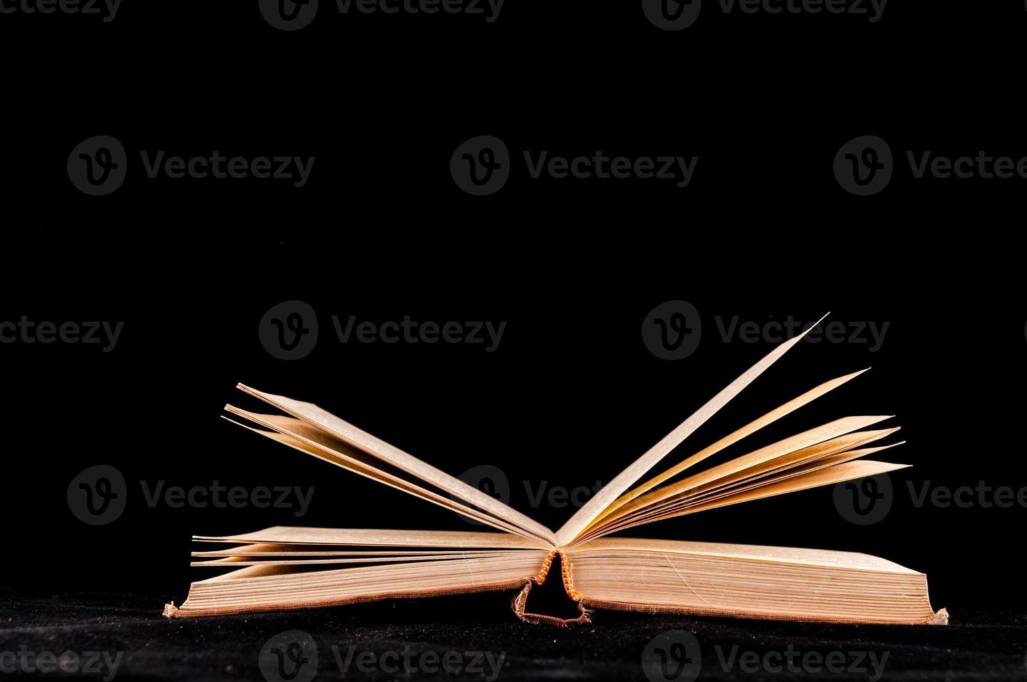 Opened book isolated on black background photo