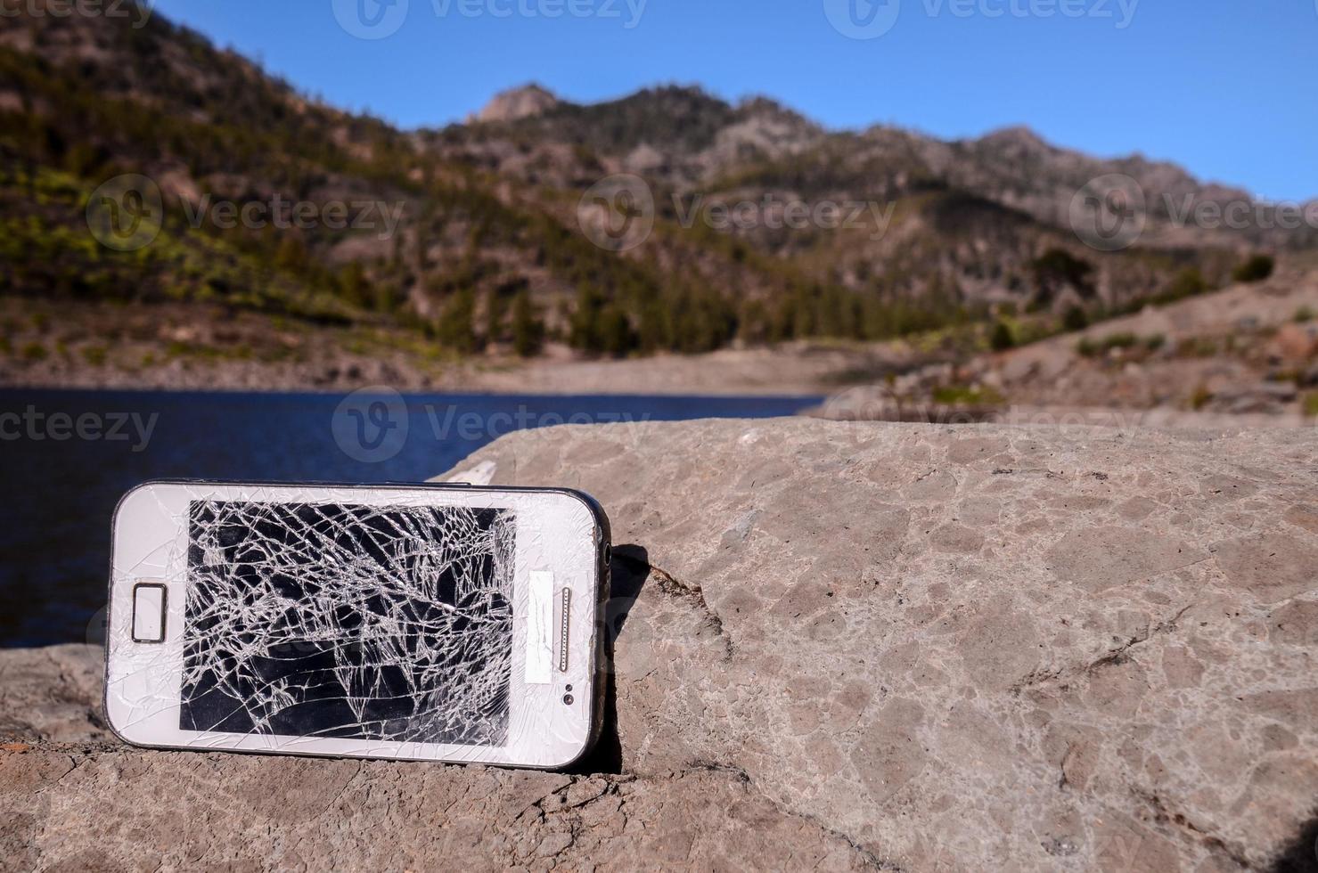 teléfono roto en una roca foto