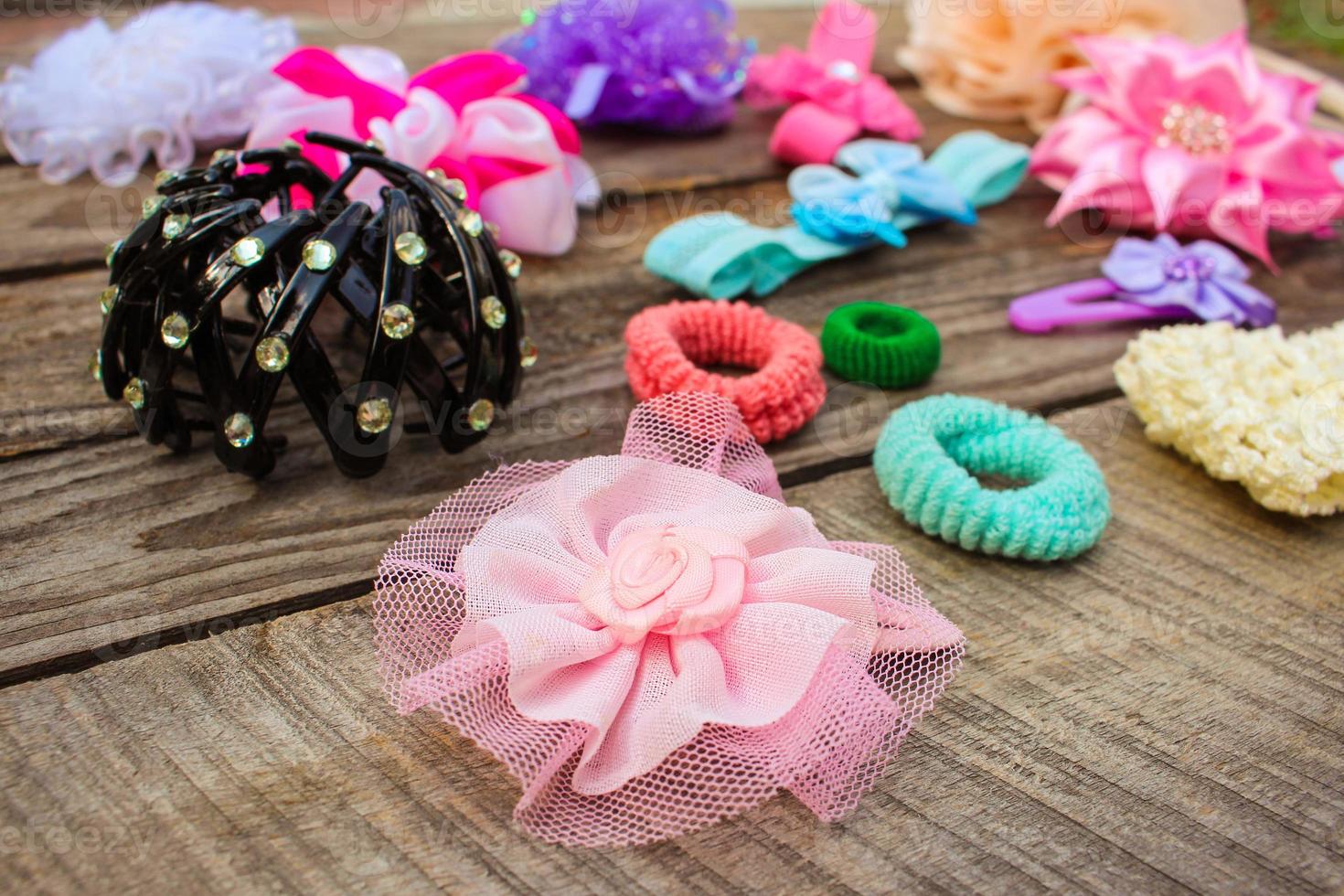 Different hair clips on wooden background photo