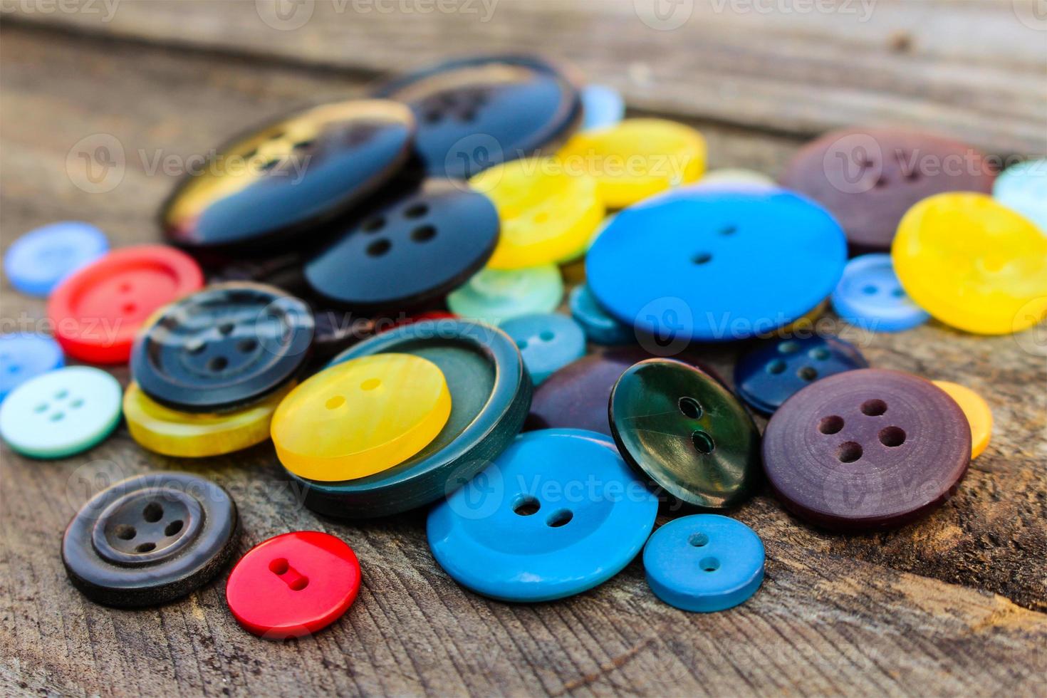 un montón de vistoso botones para ropa en de madera antecedentes. foto