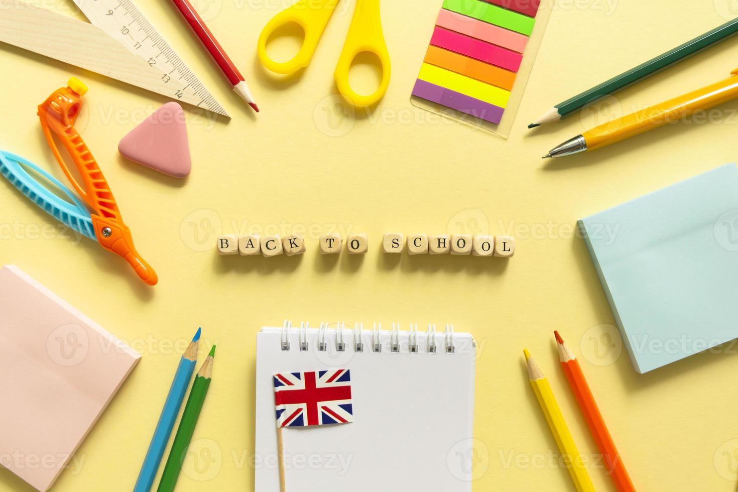 Back to school background. School accessories on a yellow background. Wooden blocks with letters photo