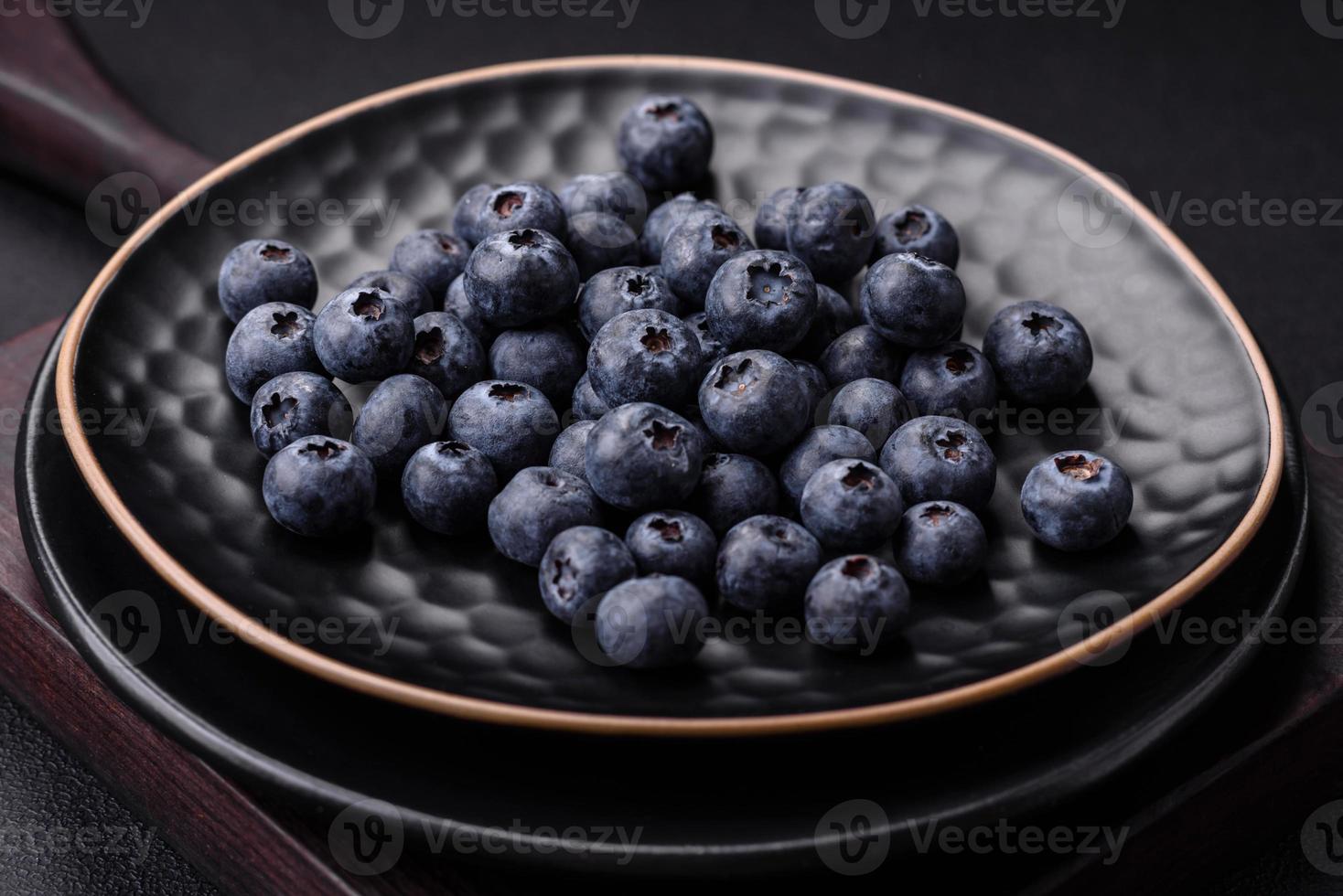 Delicious fresh blueberries on a textural black concrete background photo