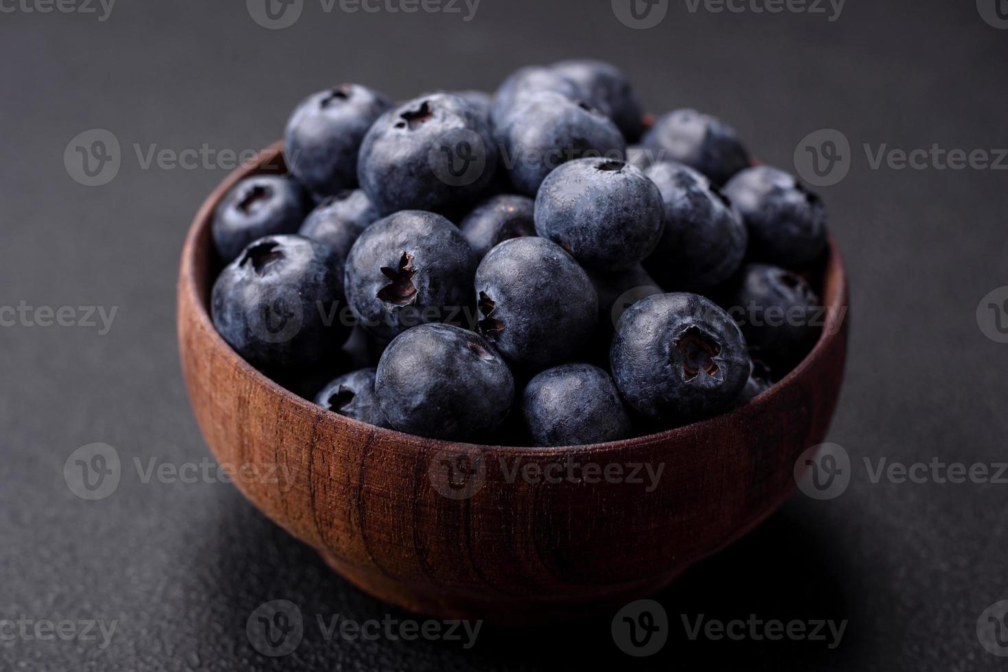 Delicious fresh blueberries on a textural black concrete background photo