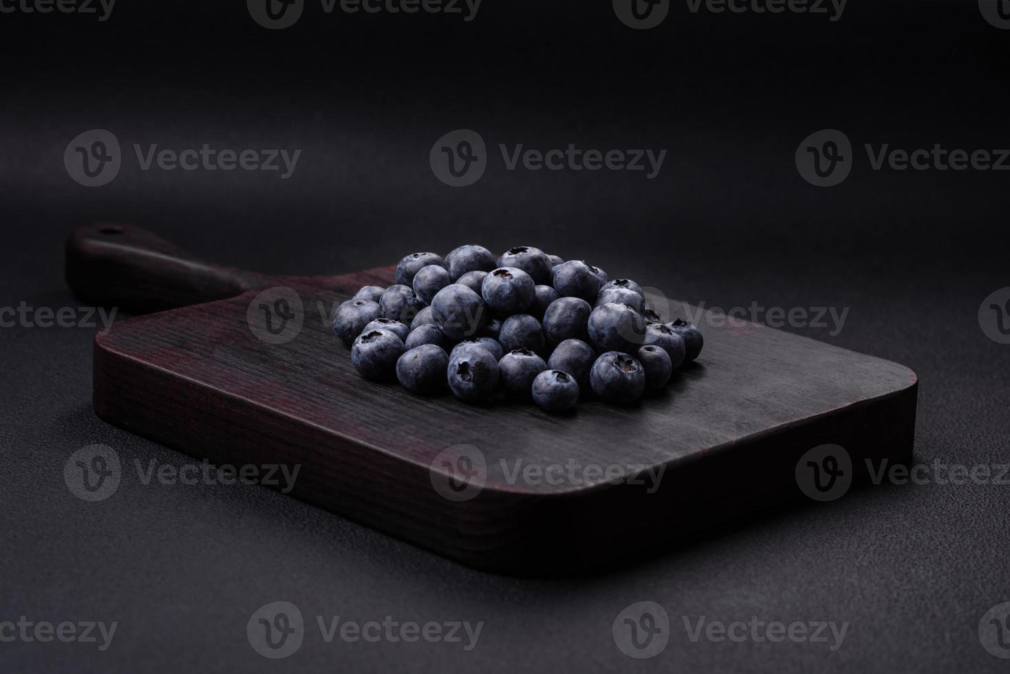 Delicious fresh blueberries on a textural black concrete background photo