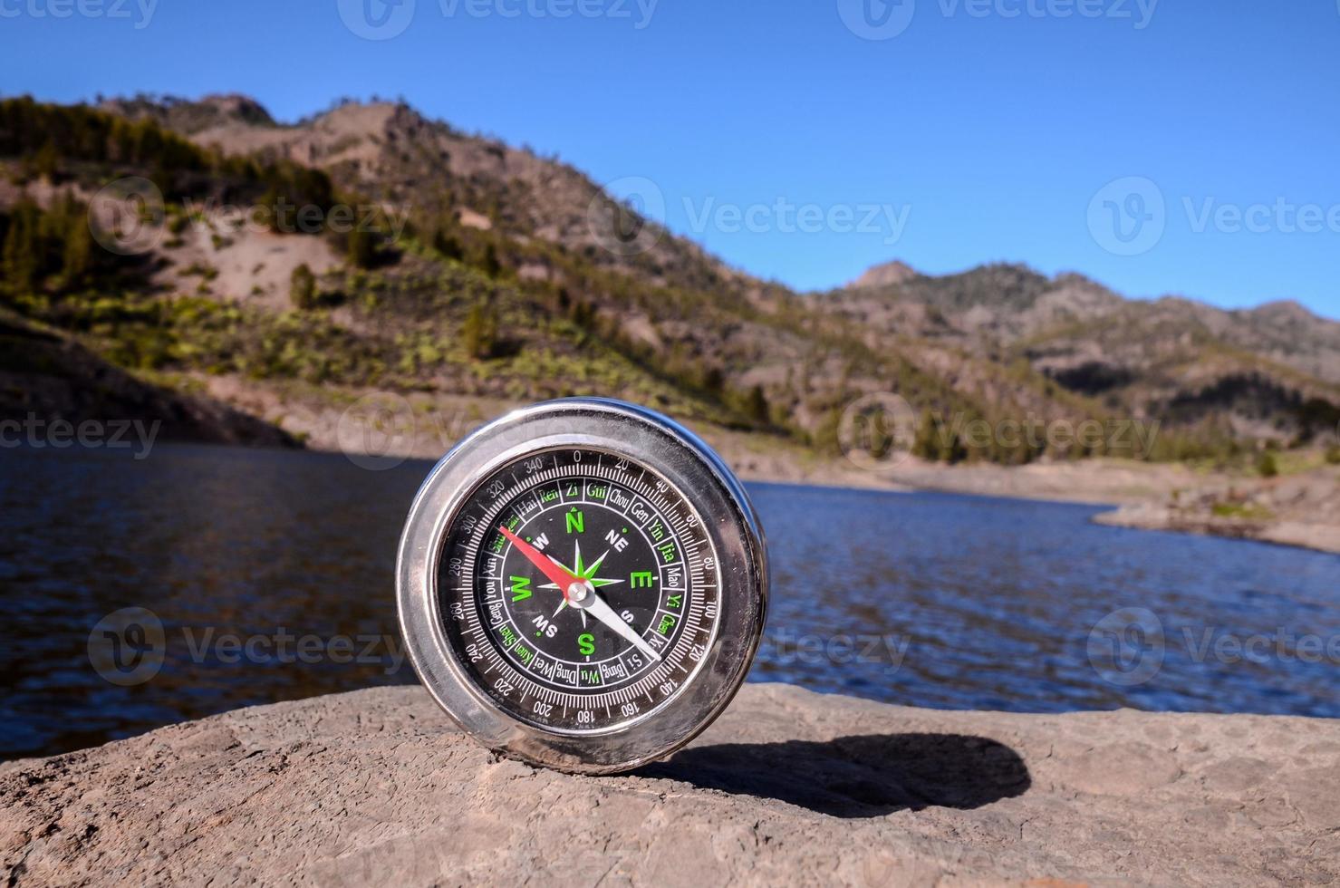 Black compass on a rock photo