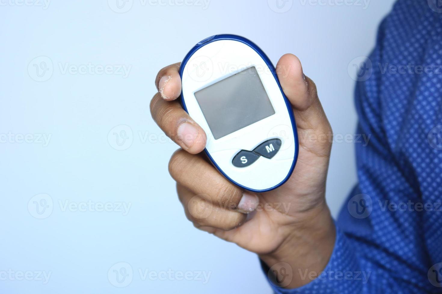 man's hand measuring blood sugar level photo