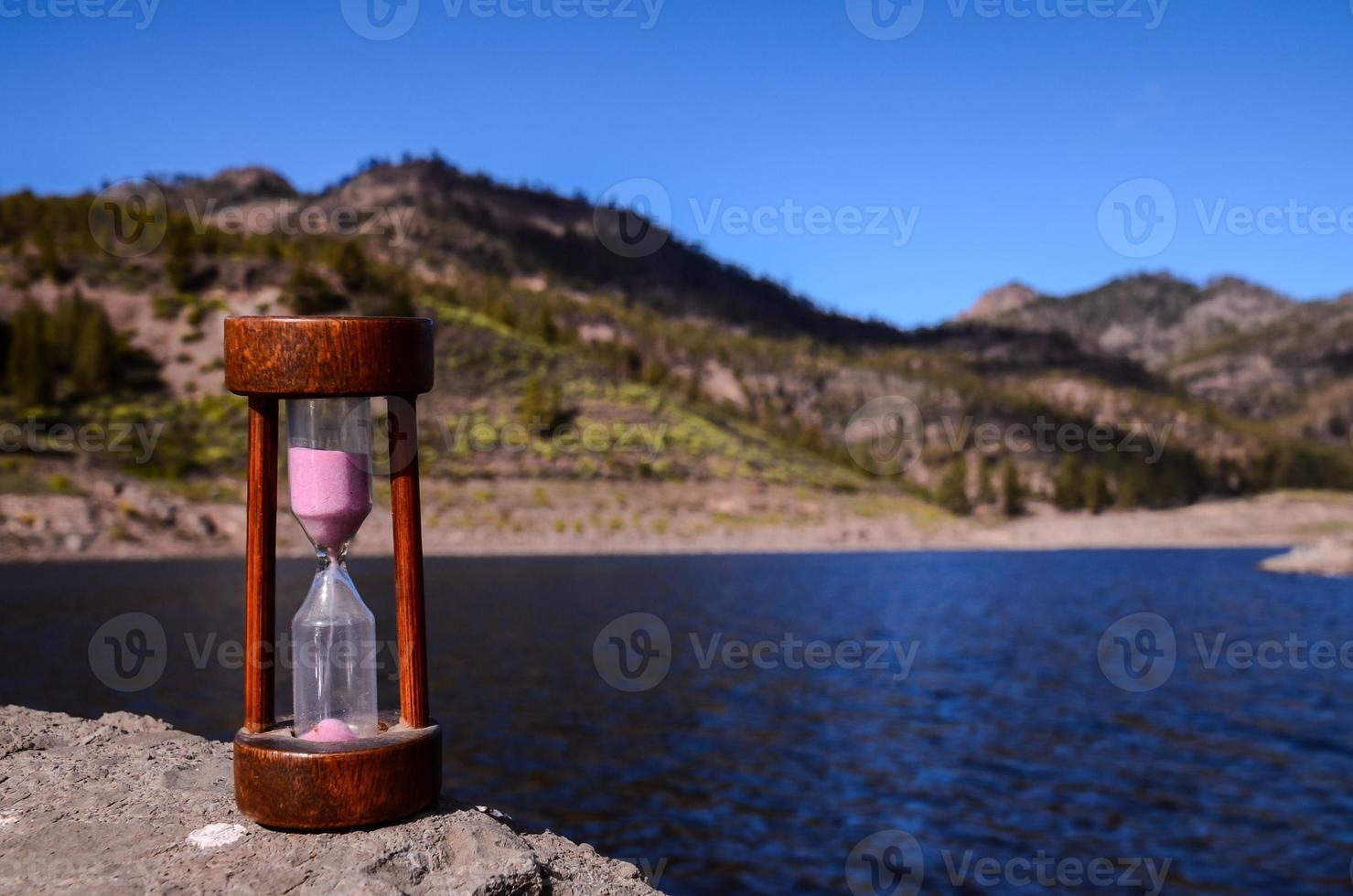 Hourglass on a rock photo
