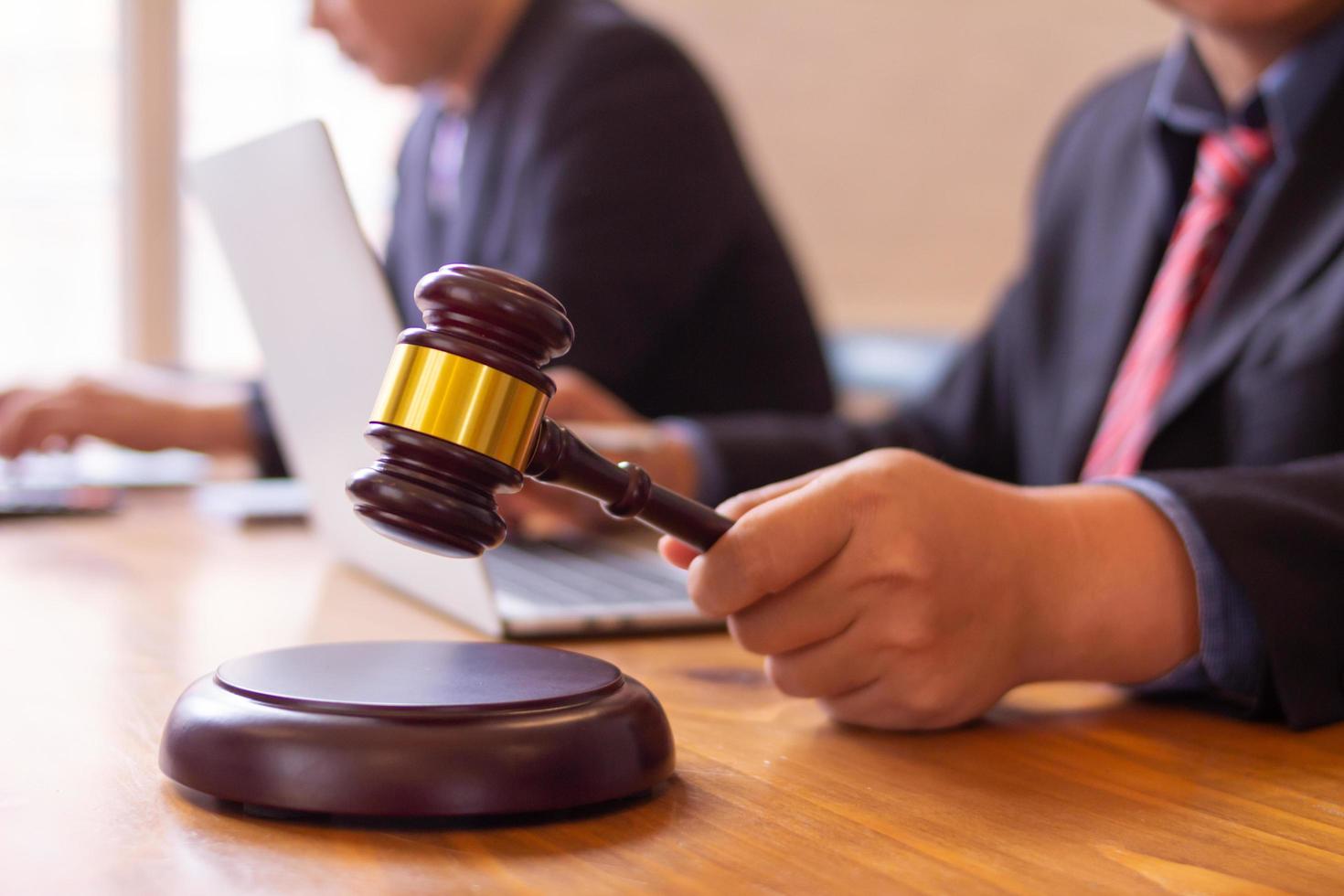 team of lawyers having legal discussion holding judges mallet in their hands to knock on the wooden keyboard. legal counsel for justice in judicial proceedings for purity and fairness of judges. photo