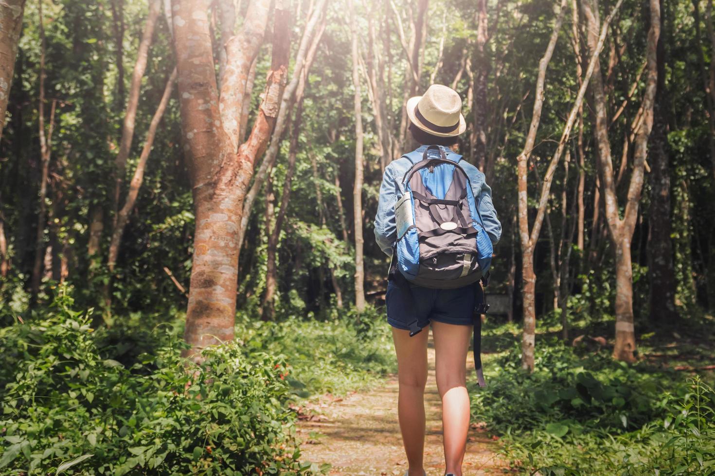 Woman traveler with backpack enjoying view and happy freedom at forest photo
