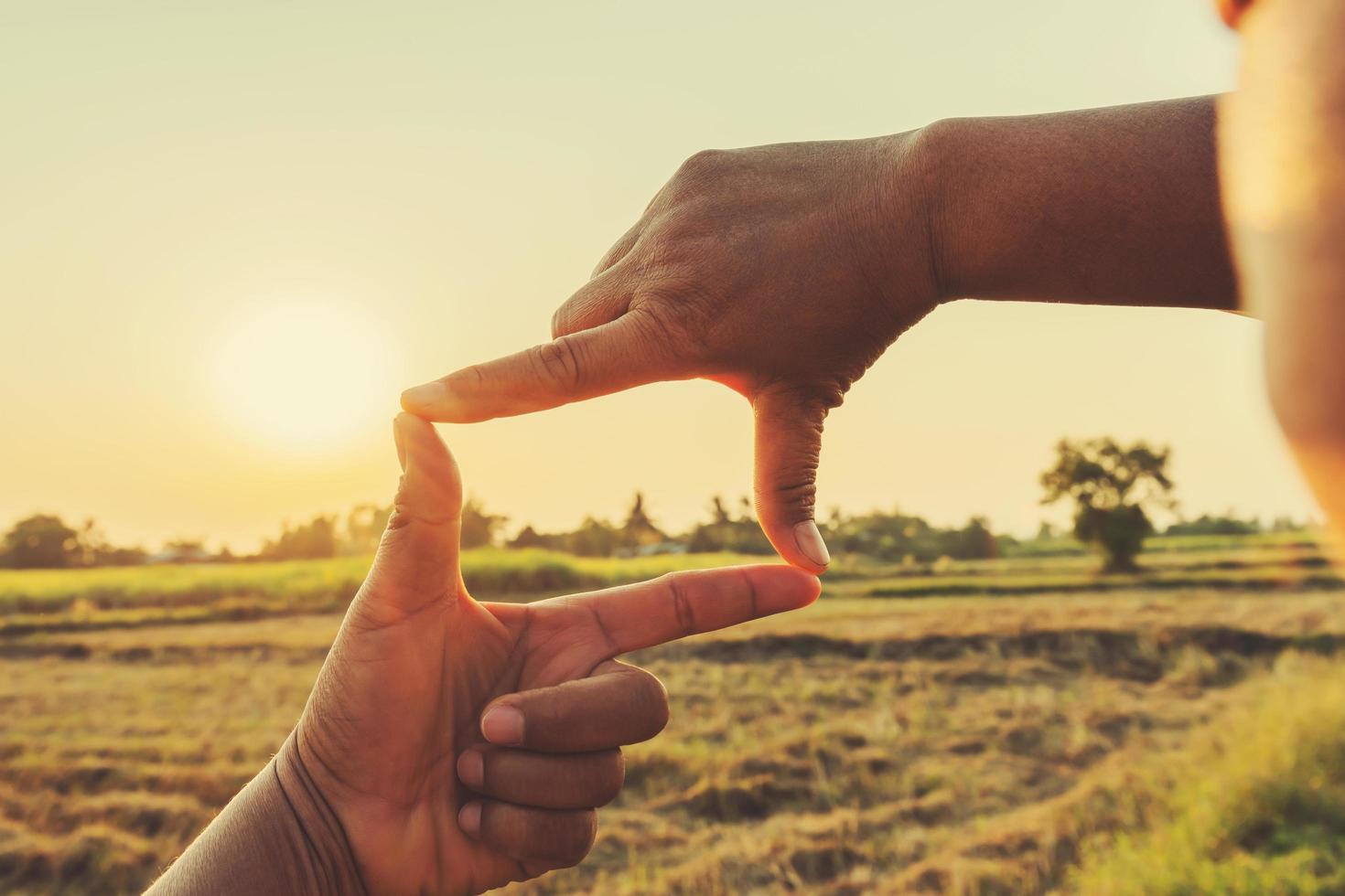 mujer mano enmarcado ver distante terminado puesta de sol. negocio concepto foto