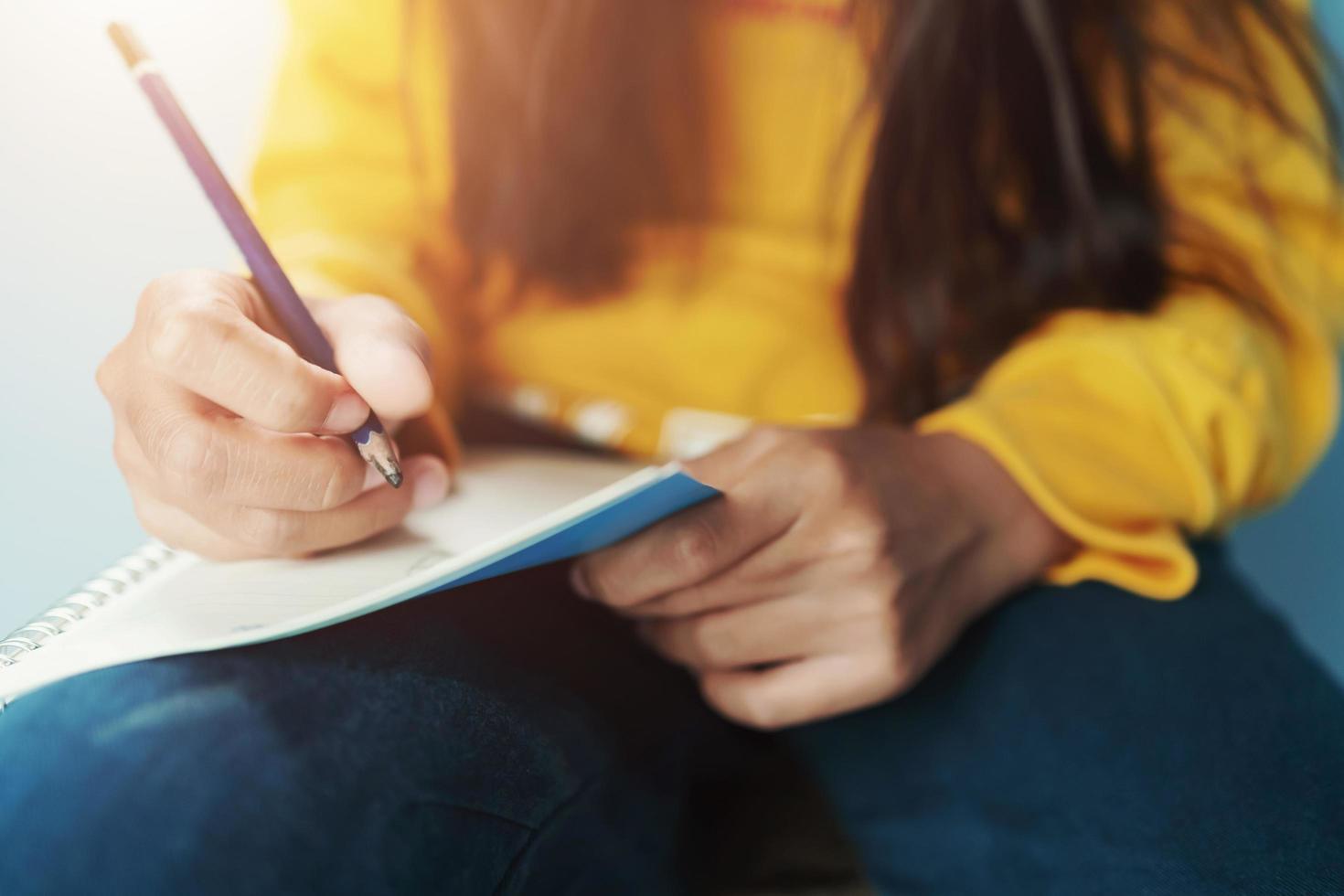 niños escritura en cuaderno por lápiz foto