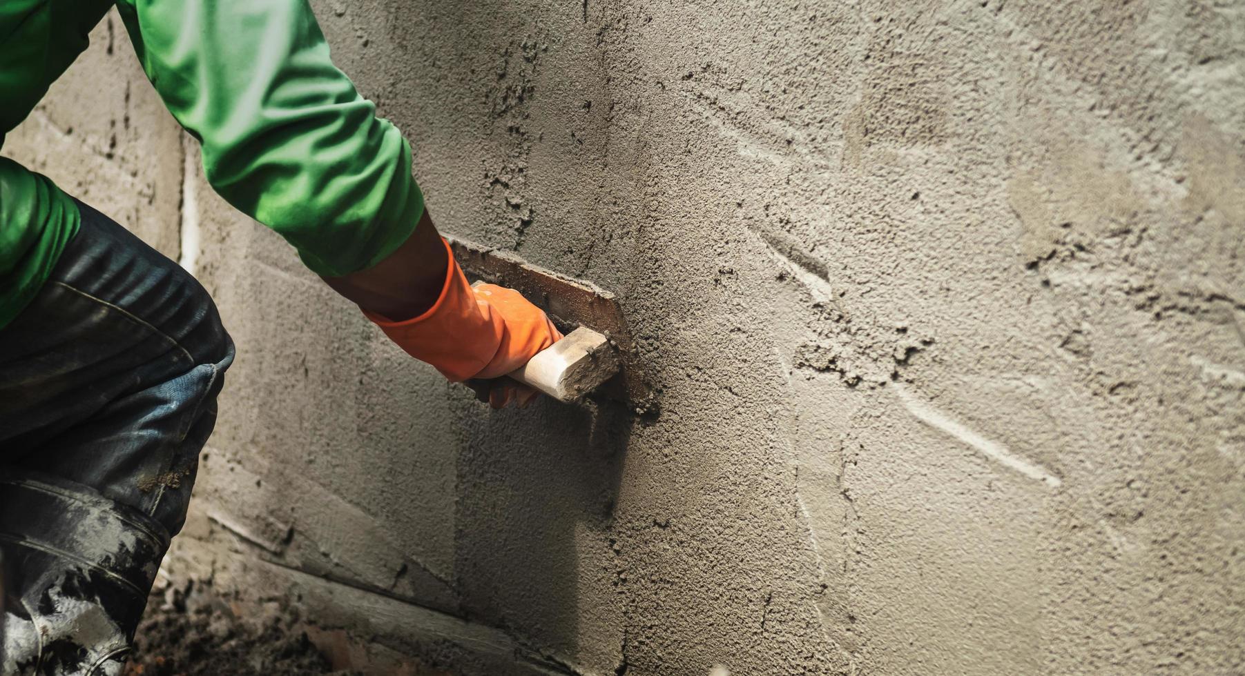 closeup hand worker plastering cement on wall for building house photo