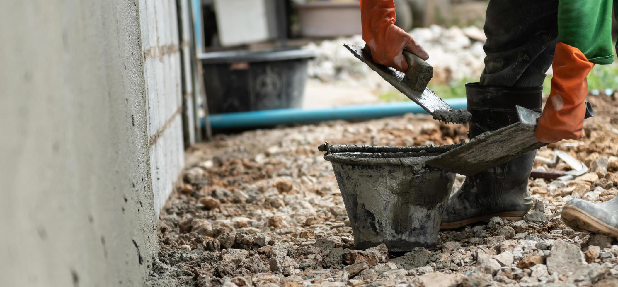 closeup hand worker plastering cement on wall for building house photo