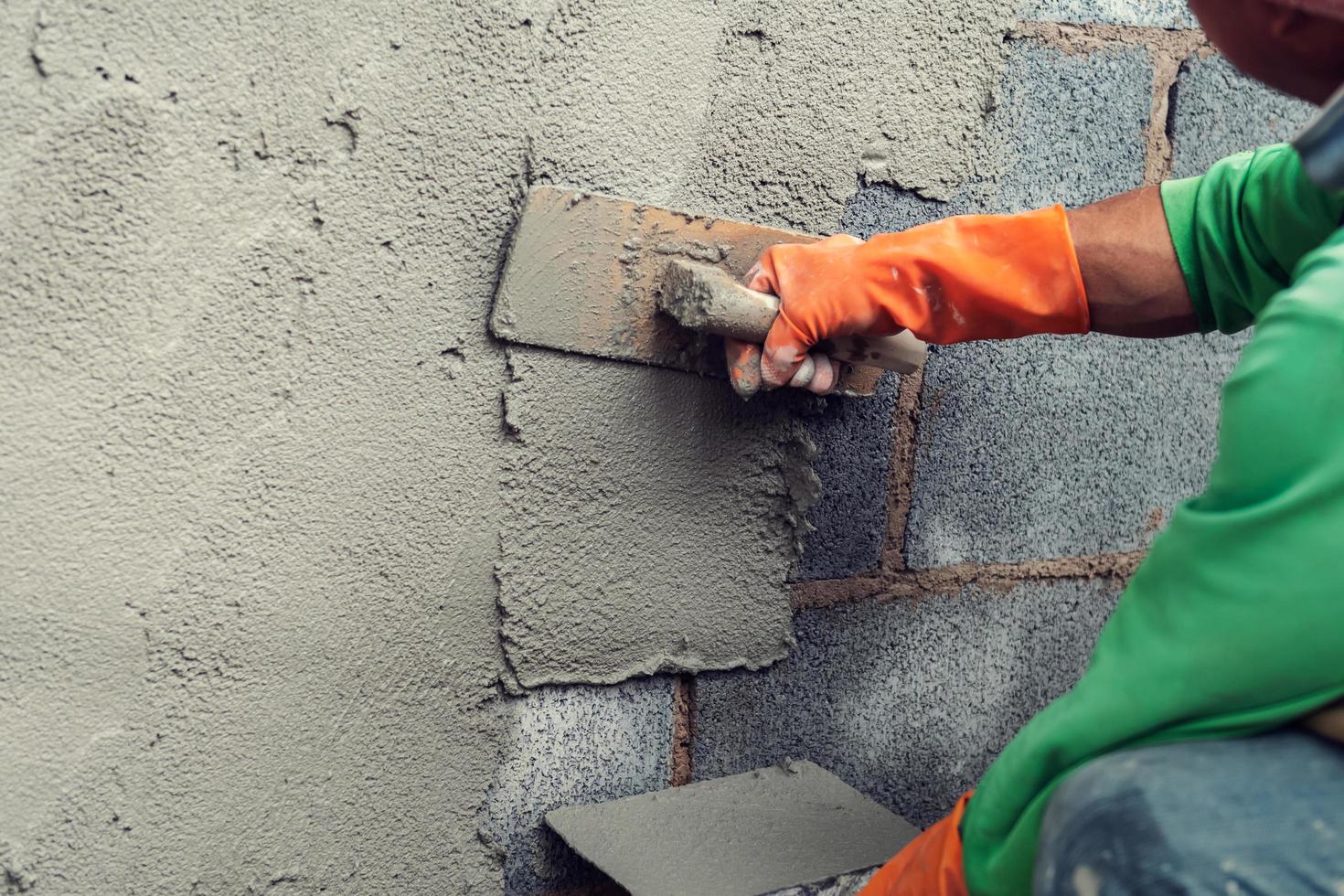 trabajador enlucido cemento en pared para edificio casa foto