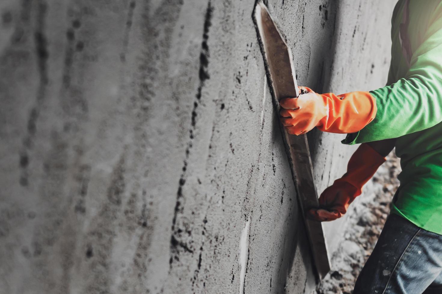 closeup hand worker plastering cement on wall for building house photo