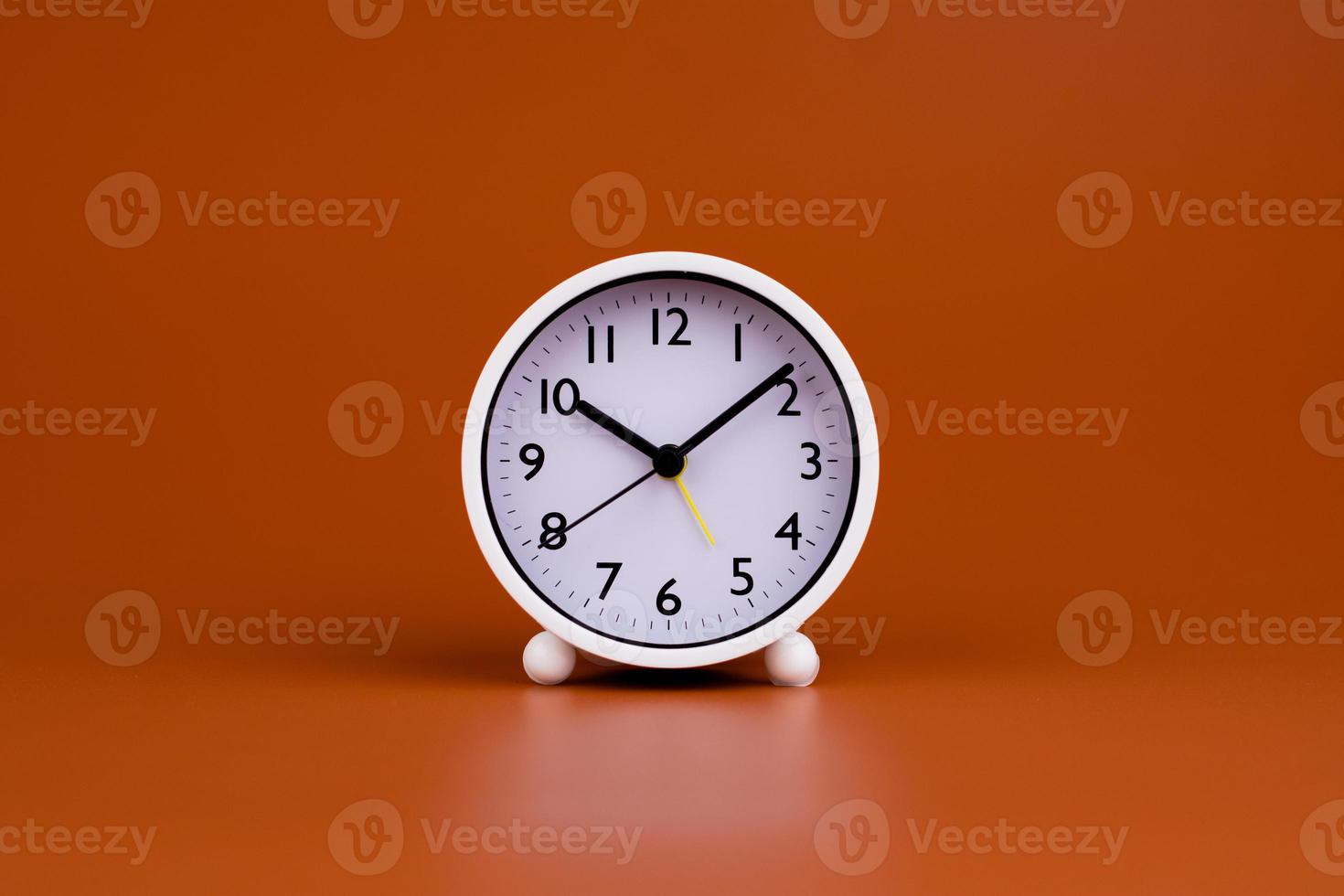 White clock on brown background, time concept working with time Planning time for life photo