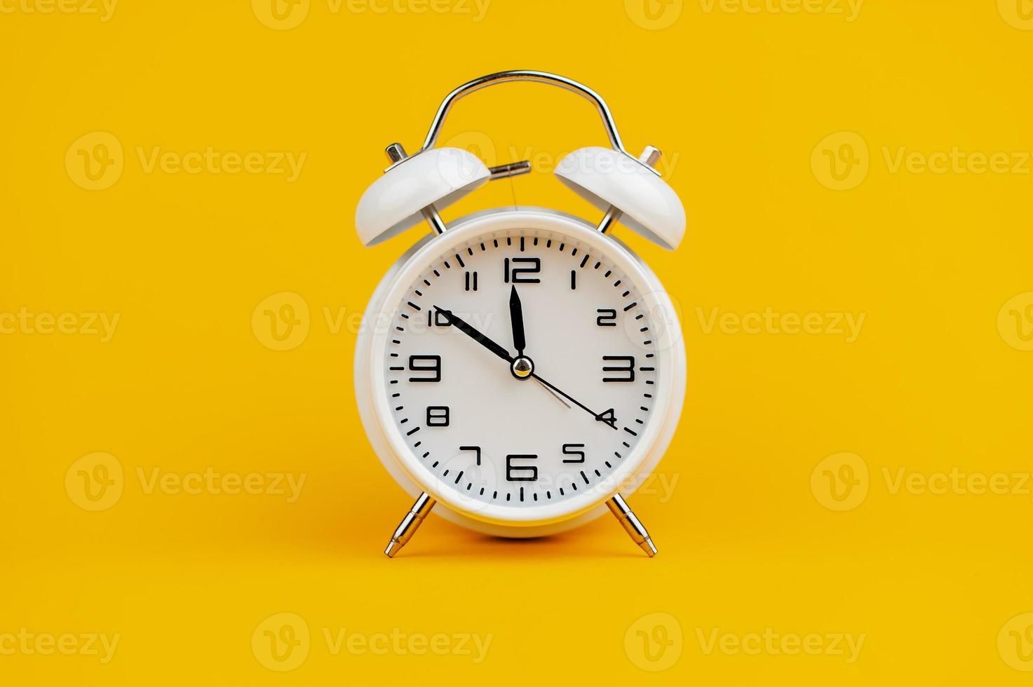 white clock on yellow background concept of time time is important to work photo