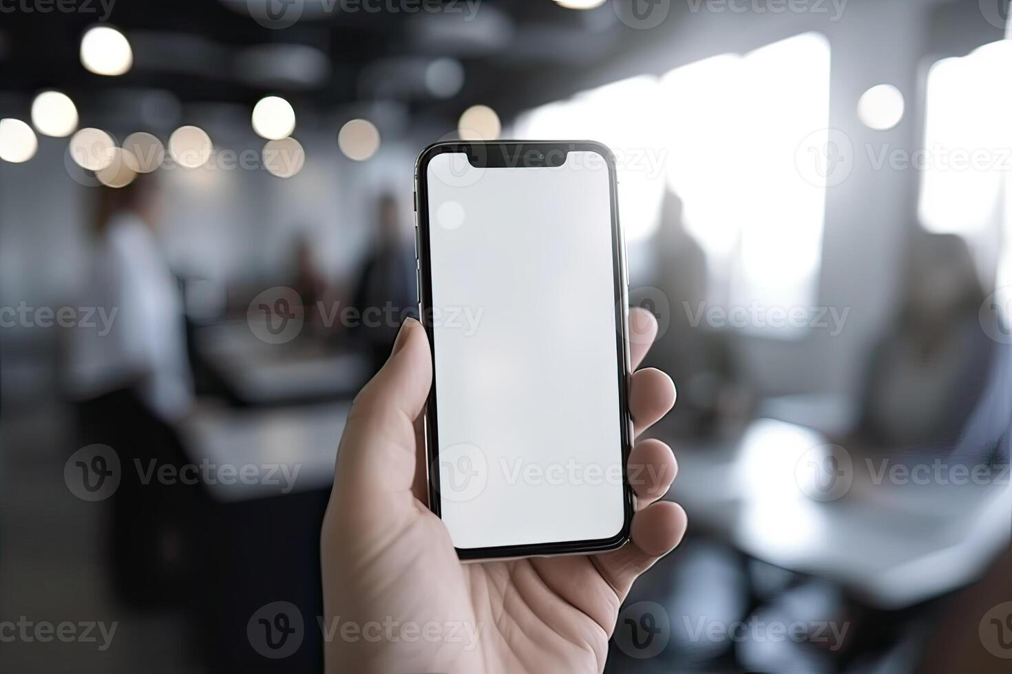 Close up view of hands holding mock up smart phone with modern office blurred background. photo