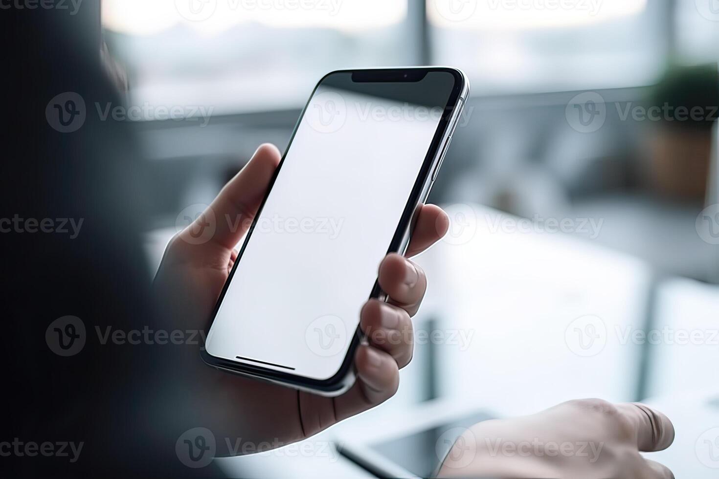 Close up view of hands holding mock up smart phone with modern office blurred background. photo