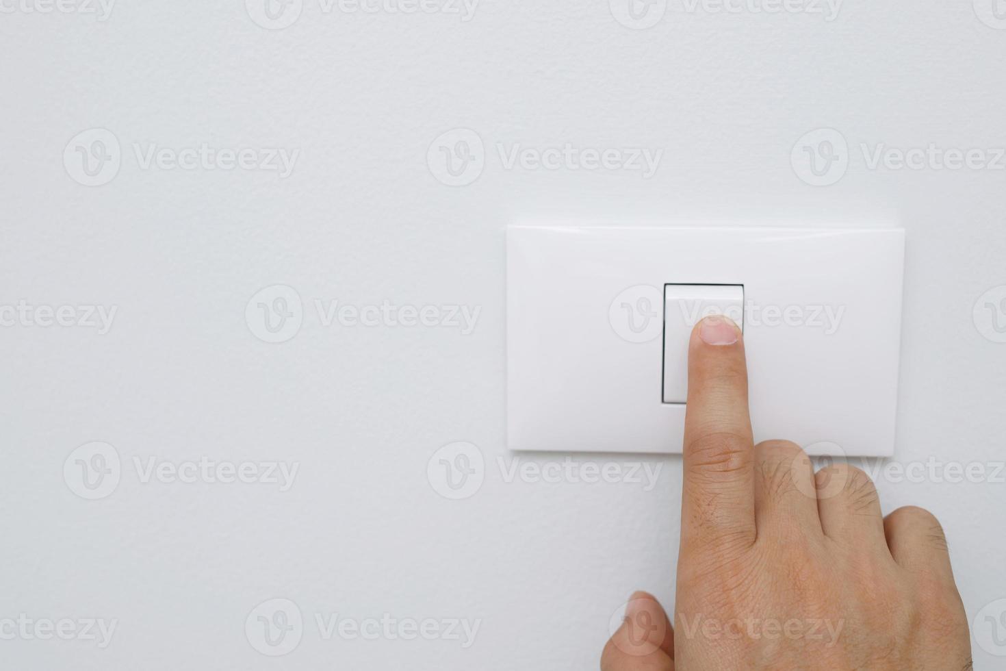 Turn off the light, close up female hand is closing the power switch. Save energy, reduce global warming. photo