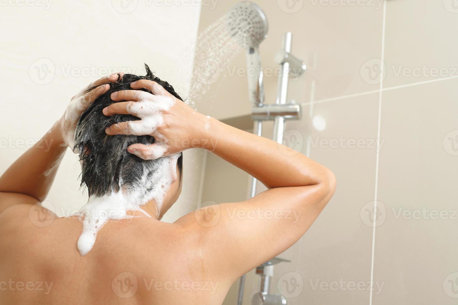 un hombre es Lavado su pelo con champú foto