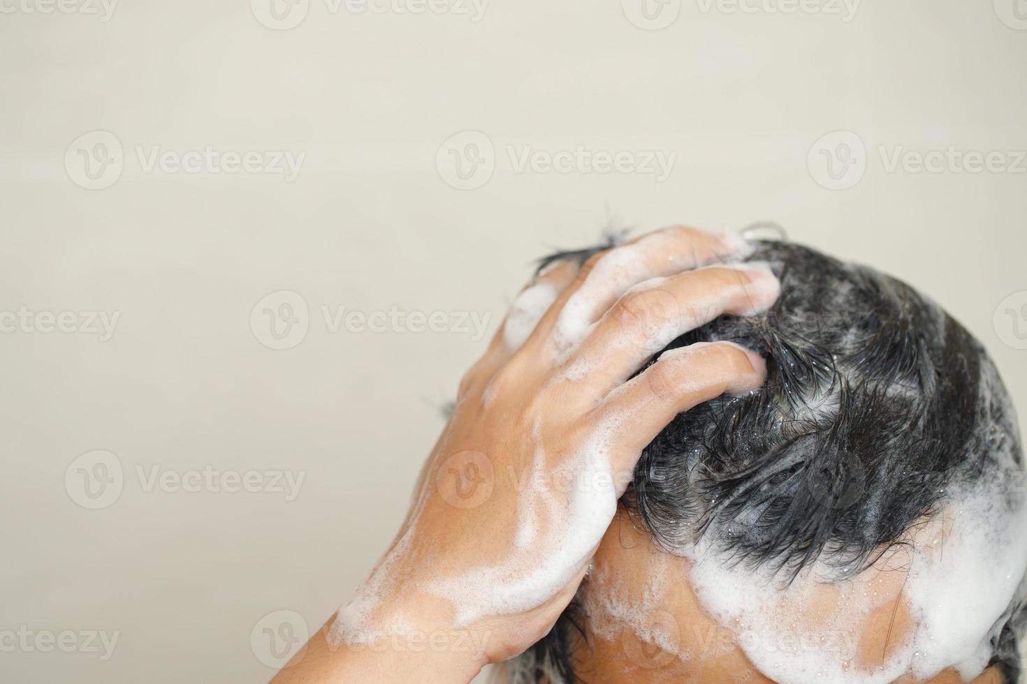 un hombre es Lavado su pelo con champú foto