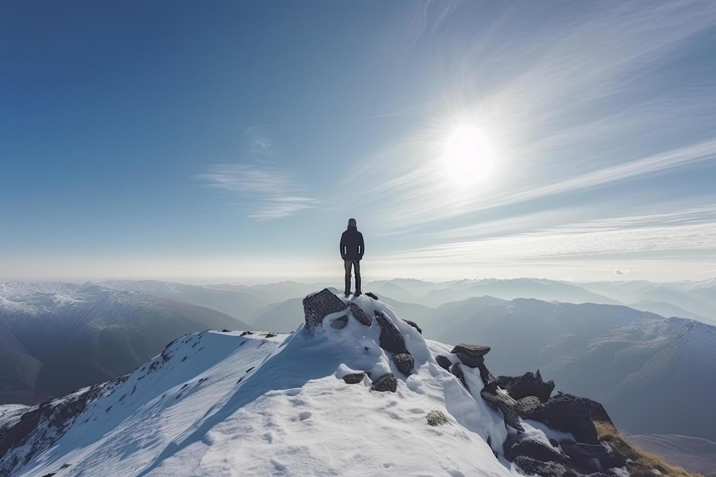 Man standing on the top of a snowcapped mountain peak. Panoramic view photo