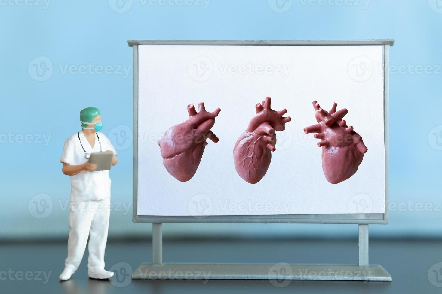 Miniature people. Doctor is diagnosing heart disease on screen photo