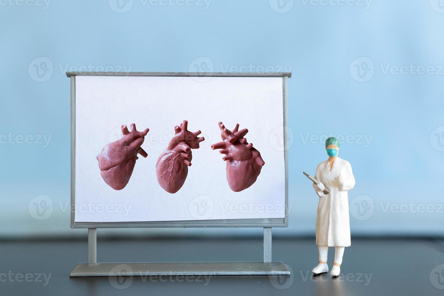 Miniature people. Doctor is diagnosing heart disease on screen photo