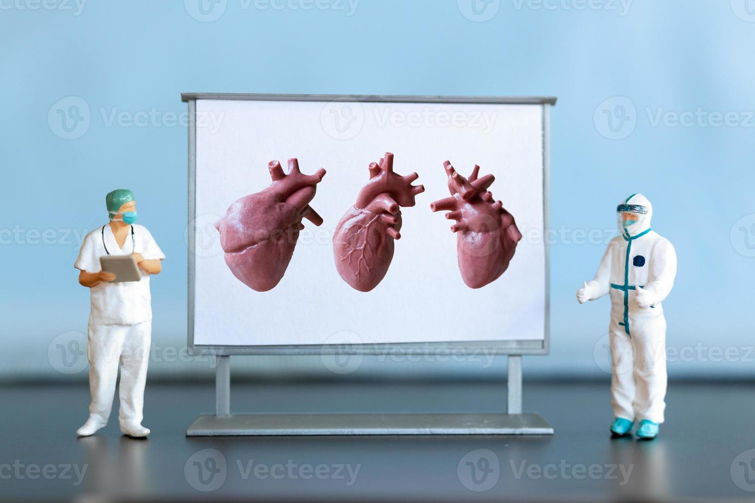 miniatura gente. médico es diagnosticando corazón enfermedad en pantalla foto