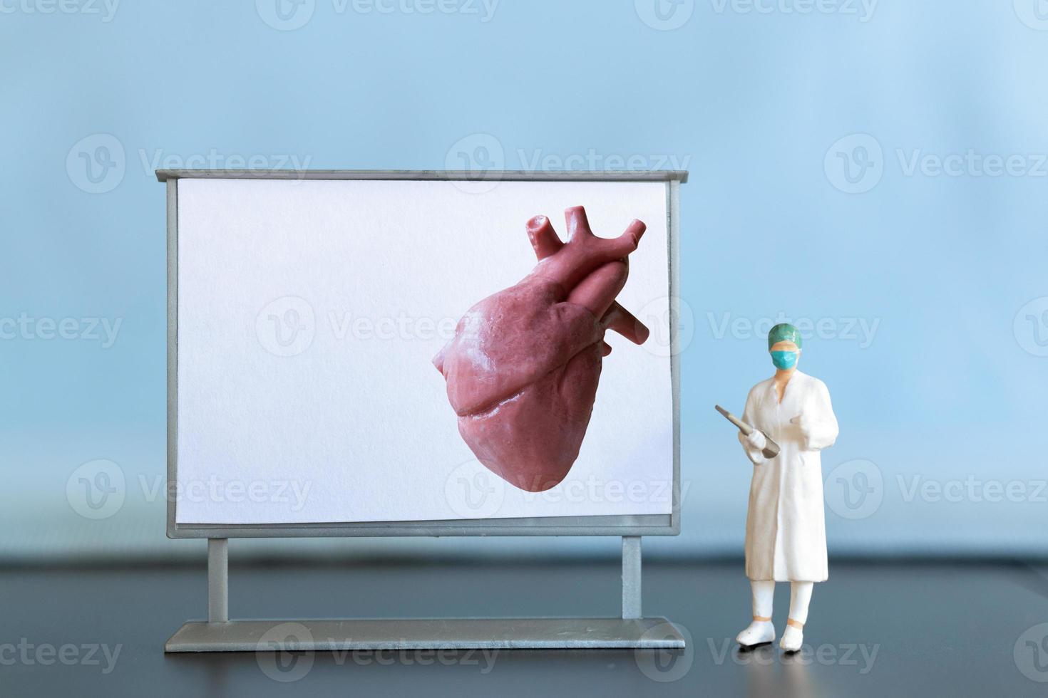 Miniature people. Doctor is diagnosing heart disease on screen photo