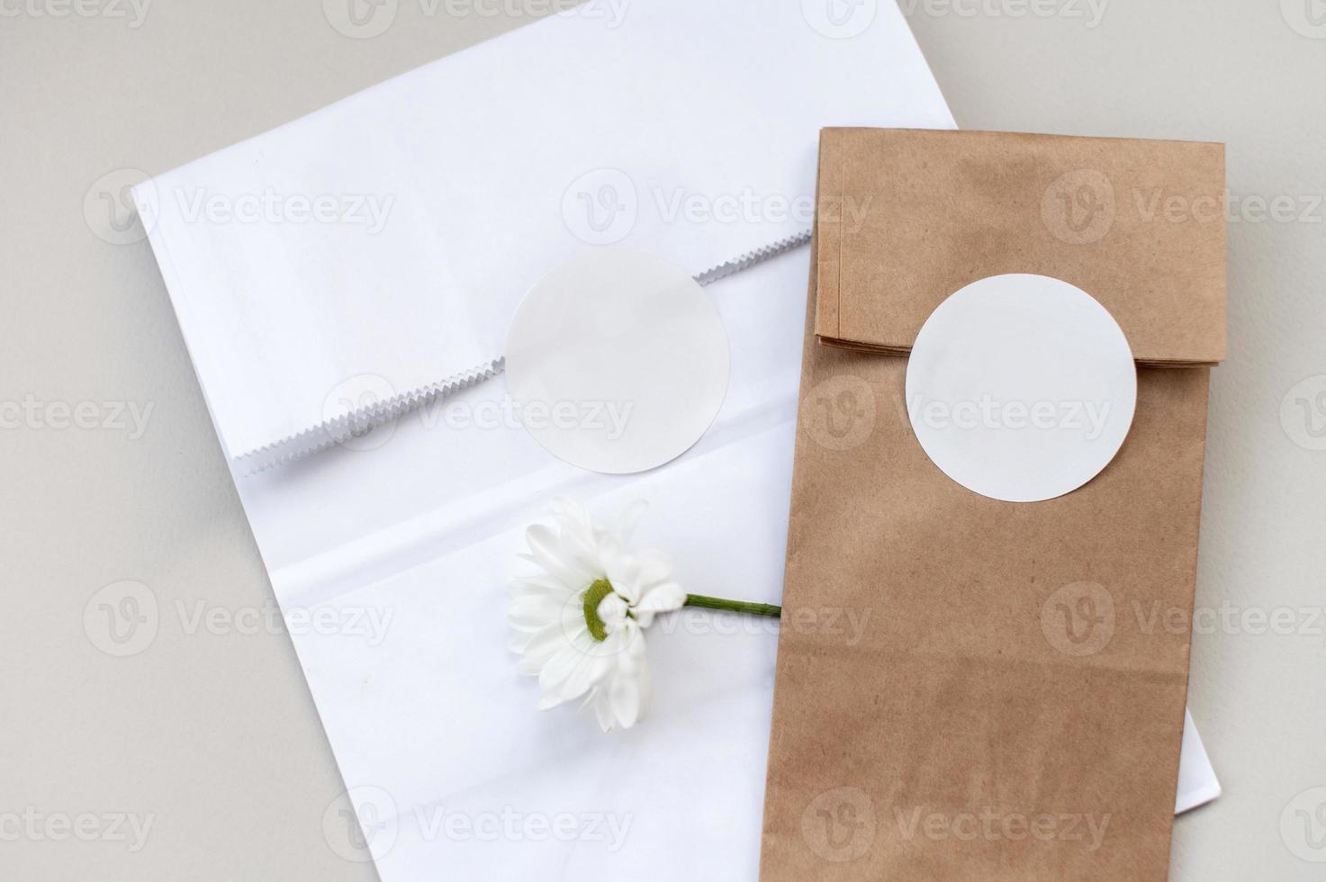 Round sticker mockup on gift white and kraft package, envelope with blank sticker, adhesive label photo