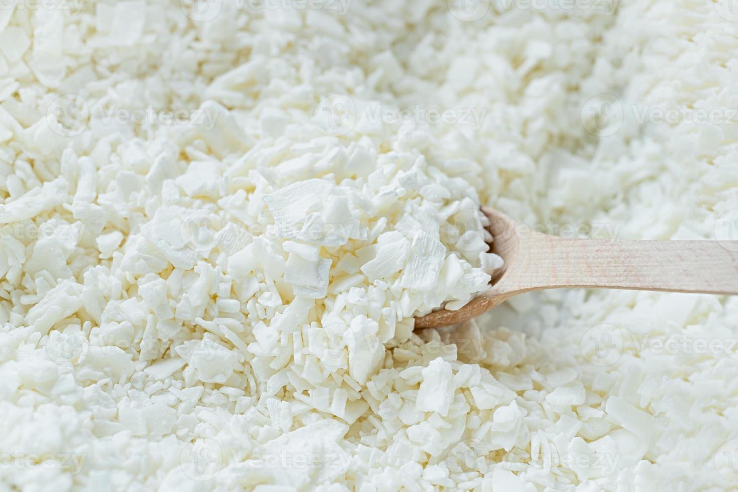closeup of wooden spoon in white soy wax flakes photo