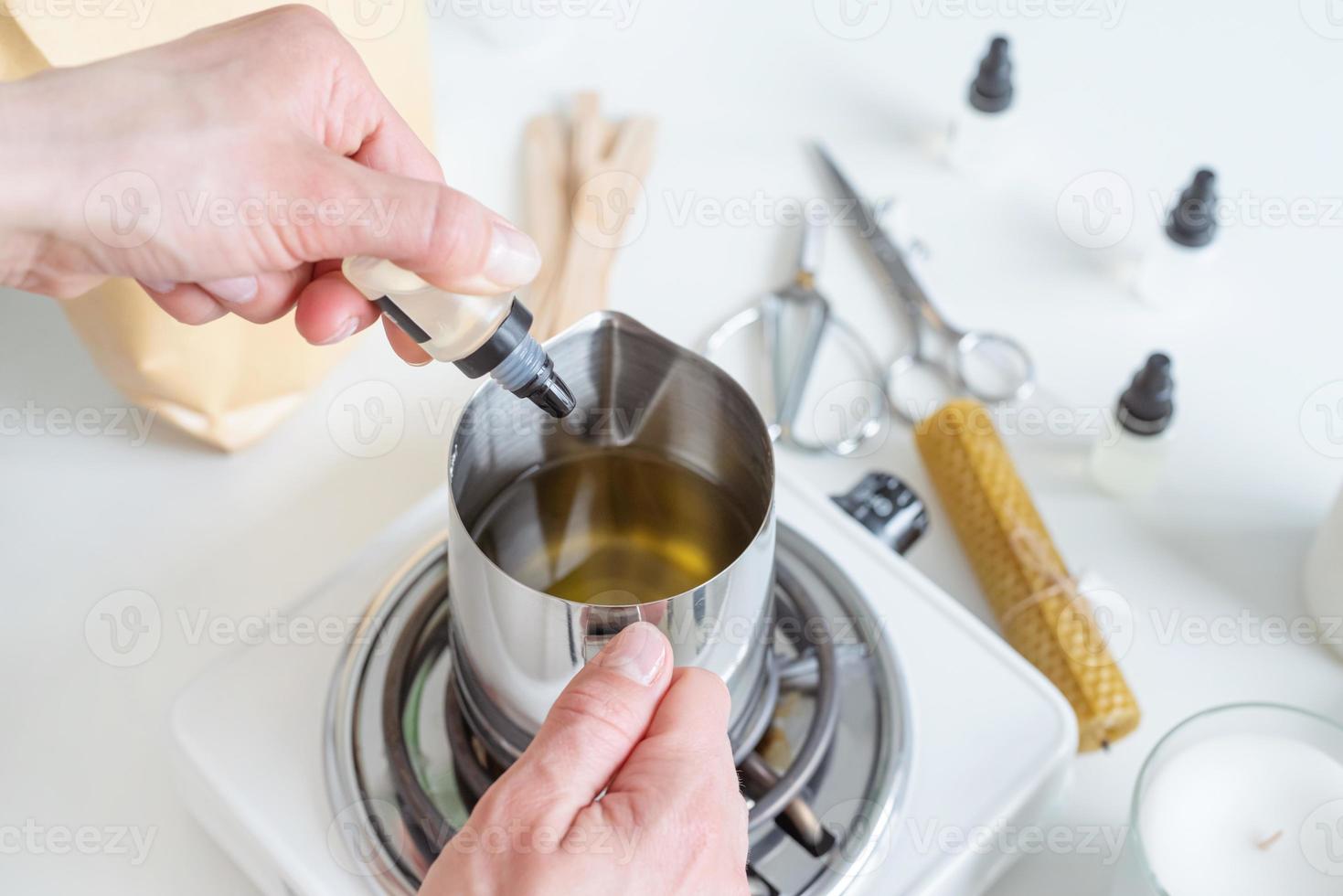 Woman making decorative aroma candle adding aroma, closeup photo