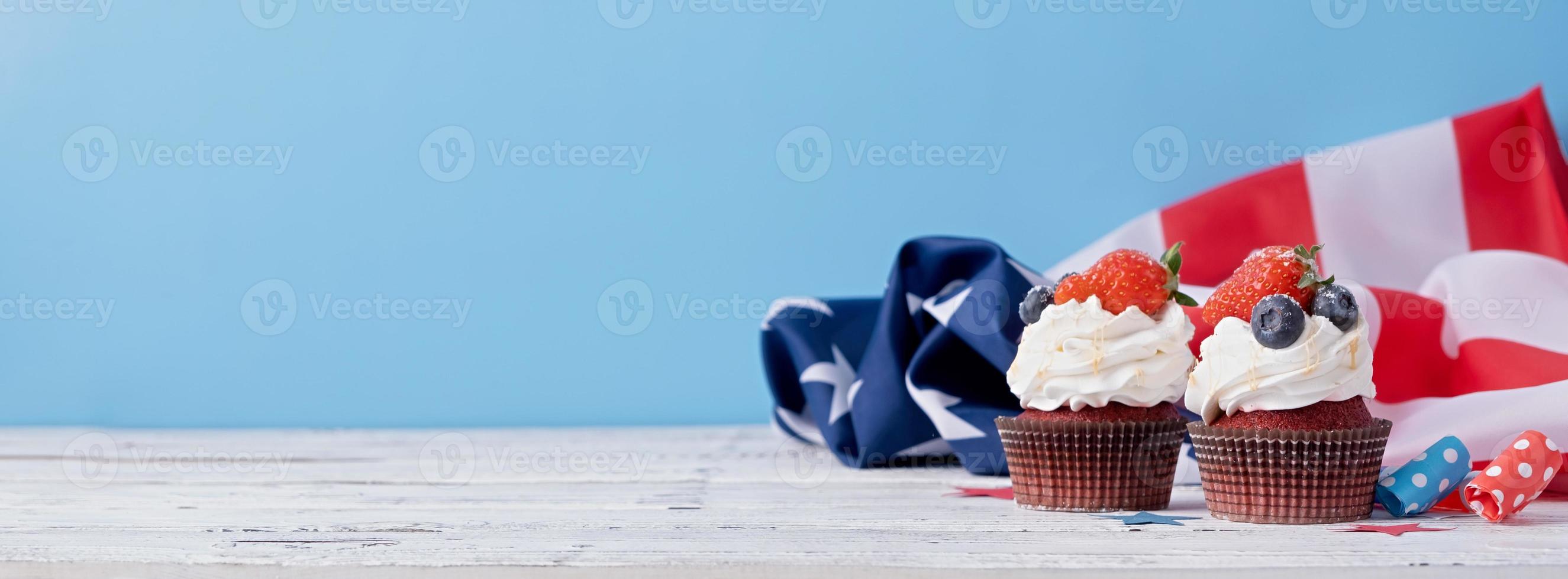 Sweet cupcakes with blueberries and strawberry , usa flag on blue background photo