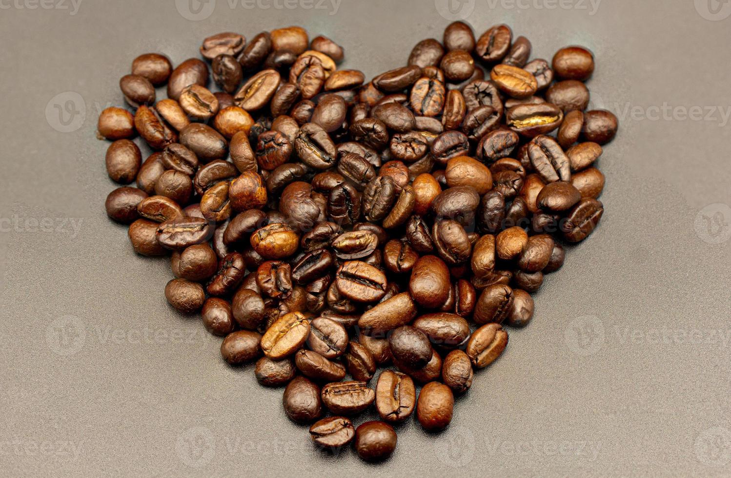 Espresso roasted coffee beans isolated in black background heart close up photo
