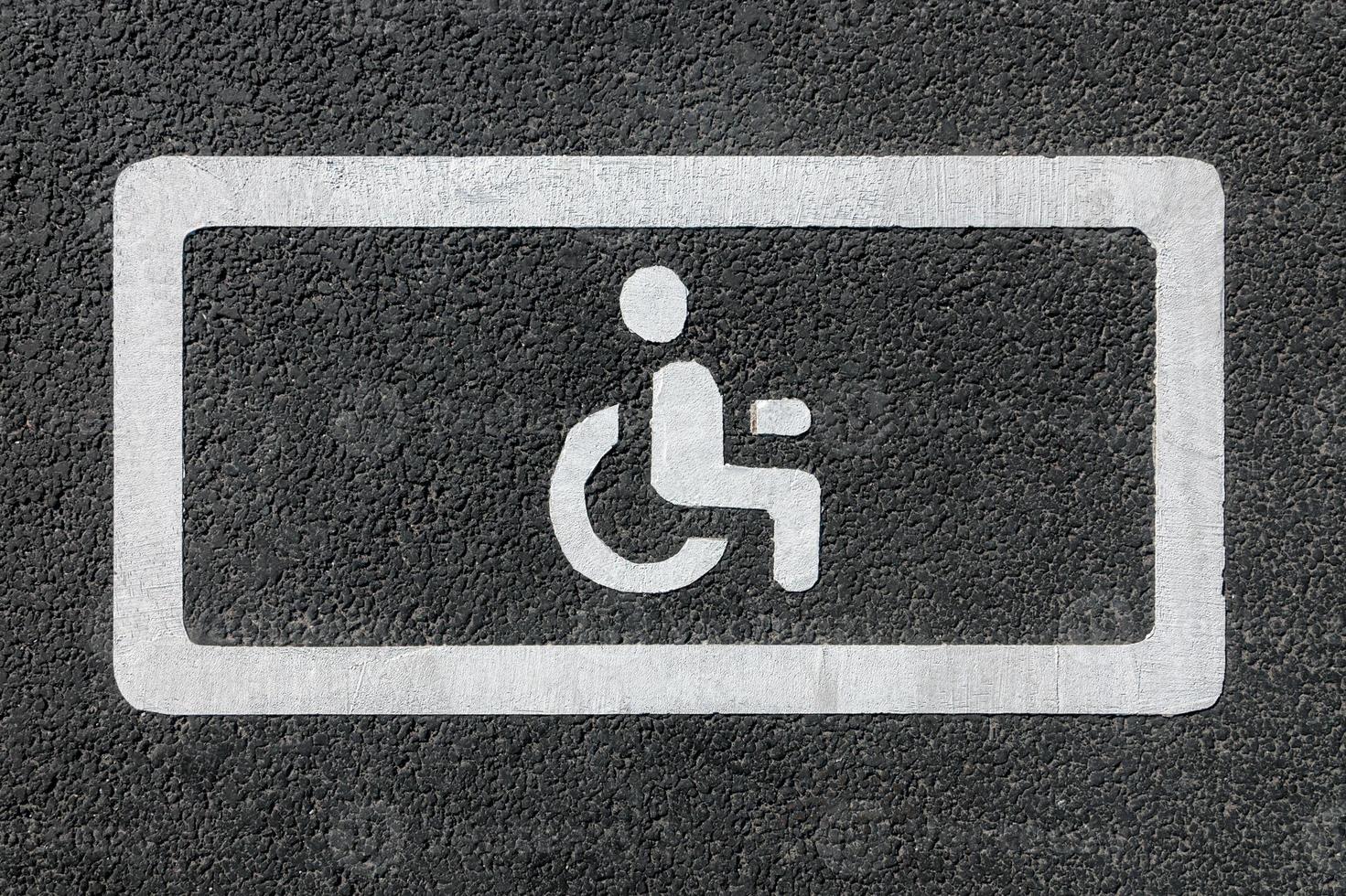 discapacitado estacionamiento firmar en asfalto la carretera - estacionamiento sitio para minusválido personas foto