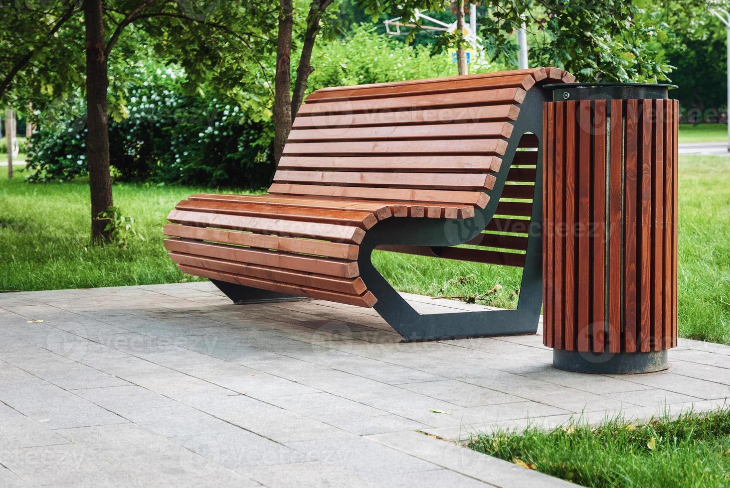 Wooden modern park bench and rubbish bin photo