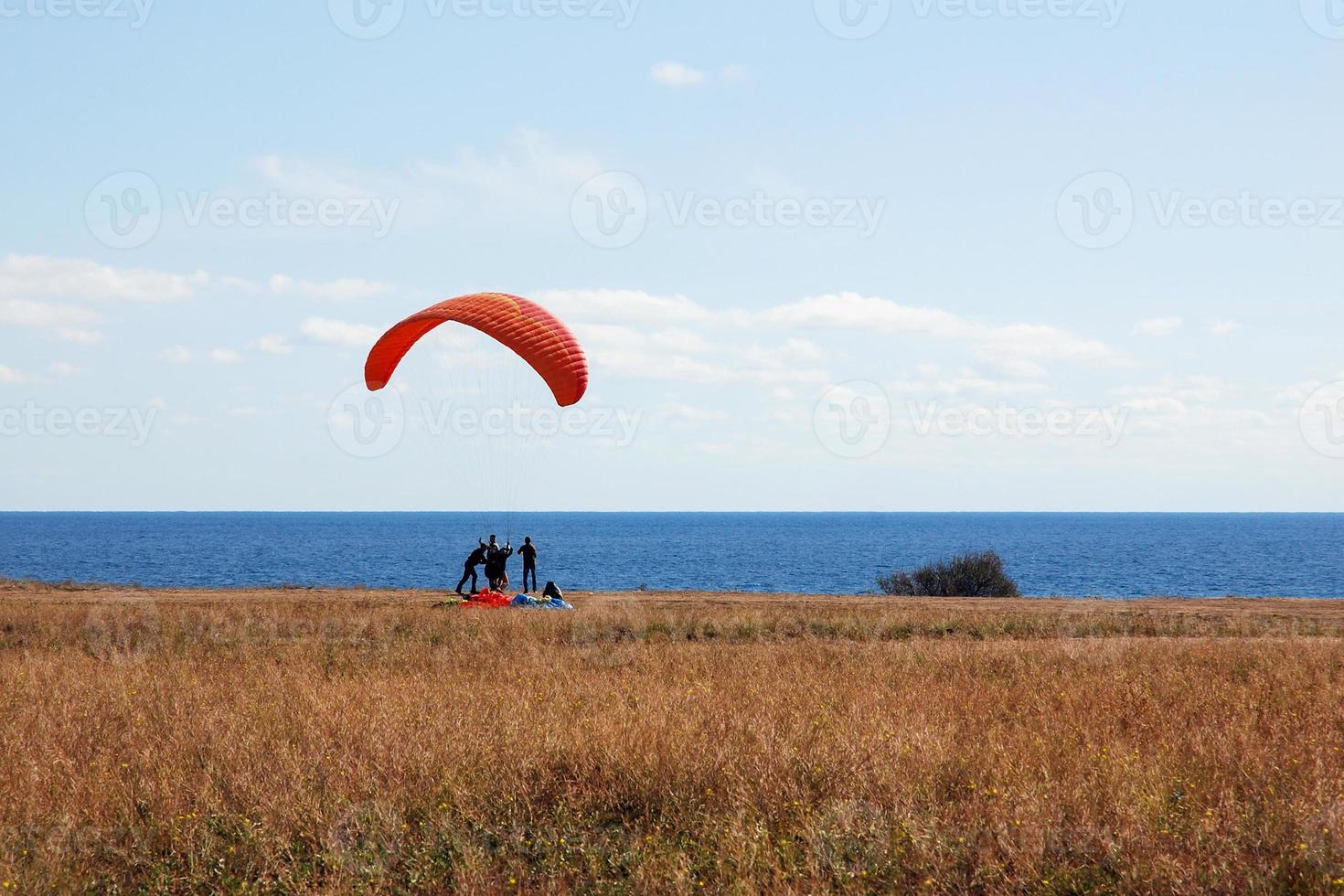 paragliders tandem at the start, sky divers training by the sea shore photo